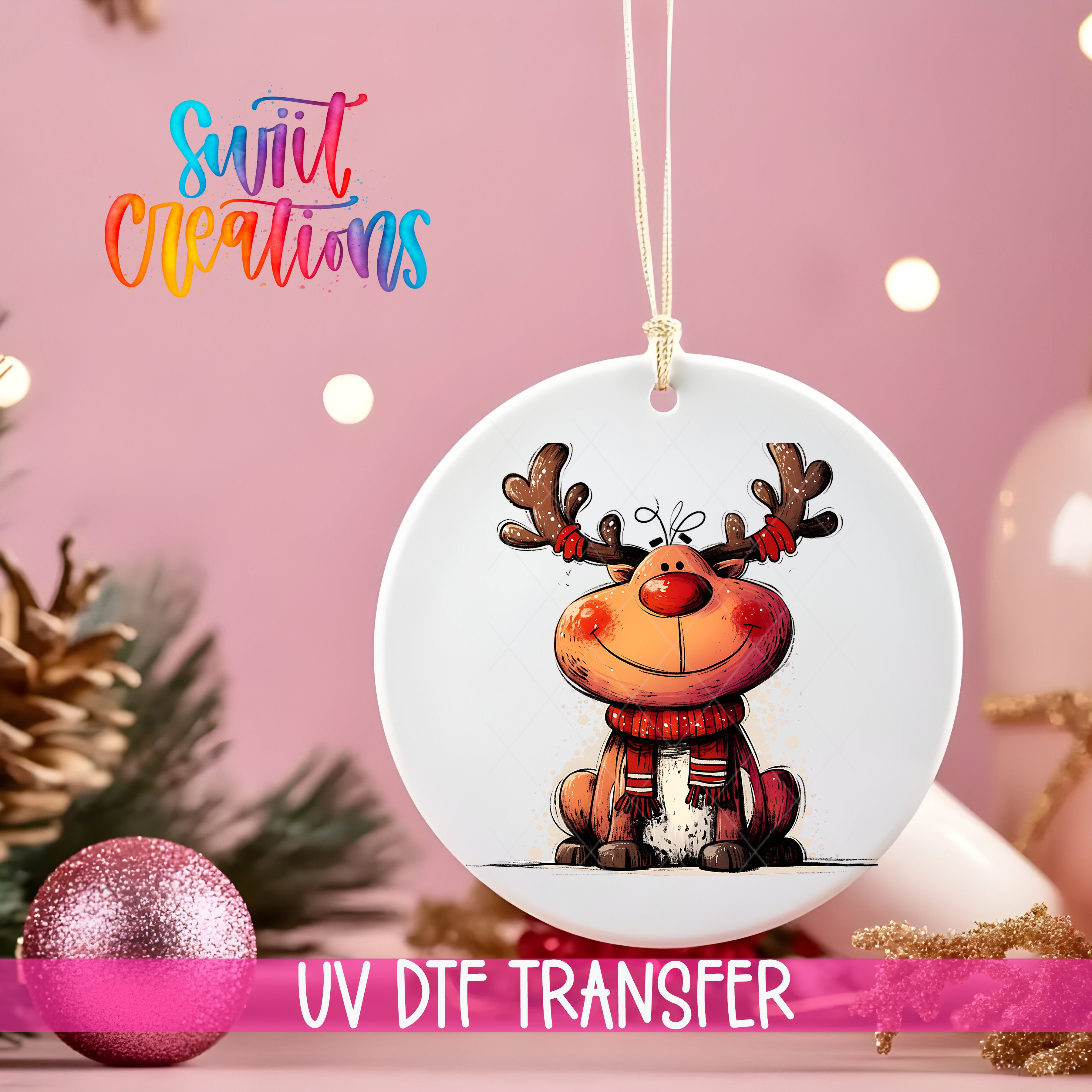 A white ornament with a cartoon reindeer design hangs against a pink background, with a pink glitter ball and Christmas tree decorations visible in the background.