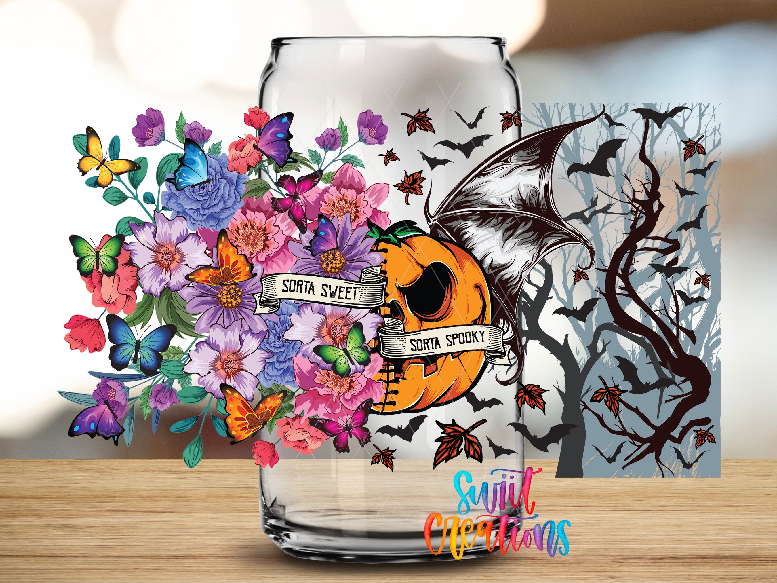 a glass jar with a Halloween-themed design, including a pumpkin, bats, flowers, and butterflies.