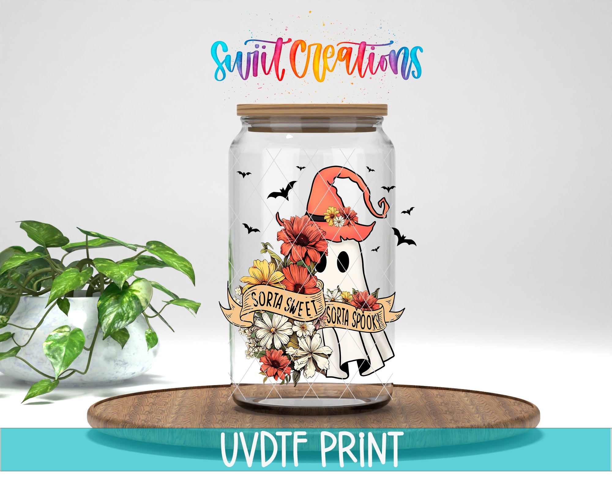 A glass jar with a ghost design and floral elements, placed on a wooden surface.