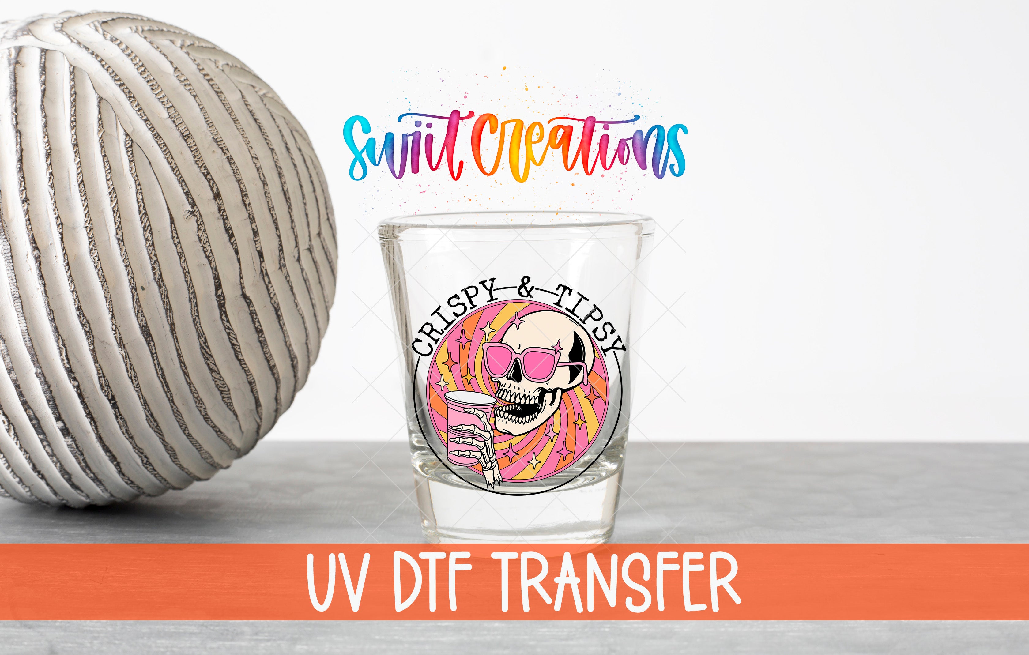 a glass with a skull wearing sunglasses and holding a drink, along with a striped ball and text related to UV DFT Transfer.