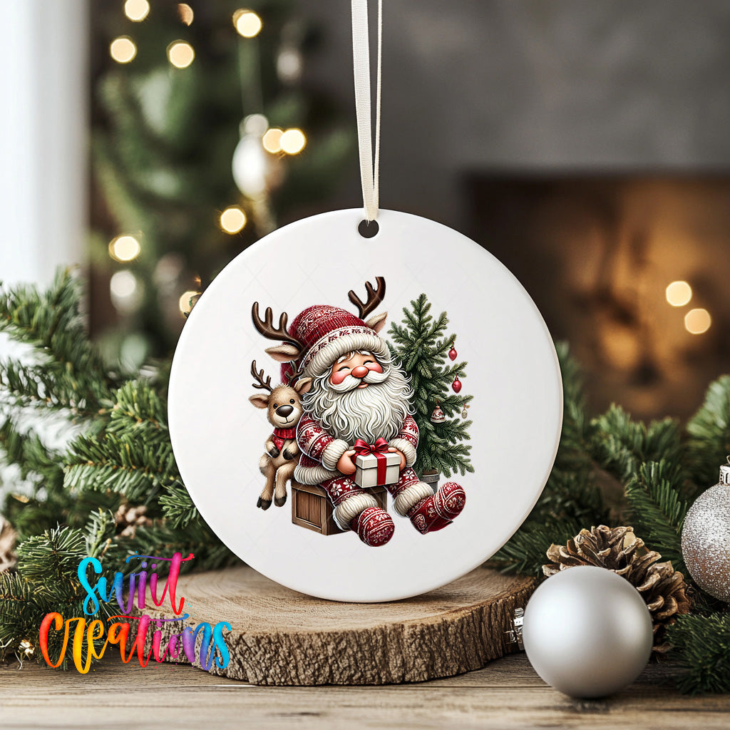 A white ceramic ornament featuring a smiling Santa Claus holding a reindeer and a gift, surrounded by Christmas decorations and greenery.