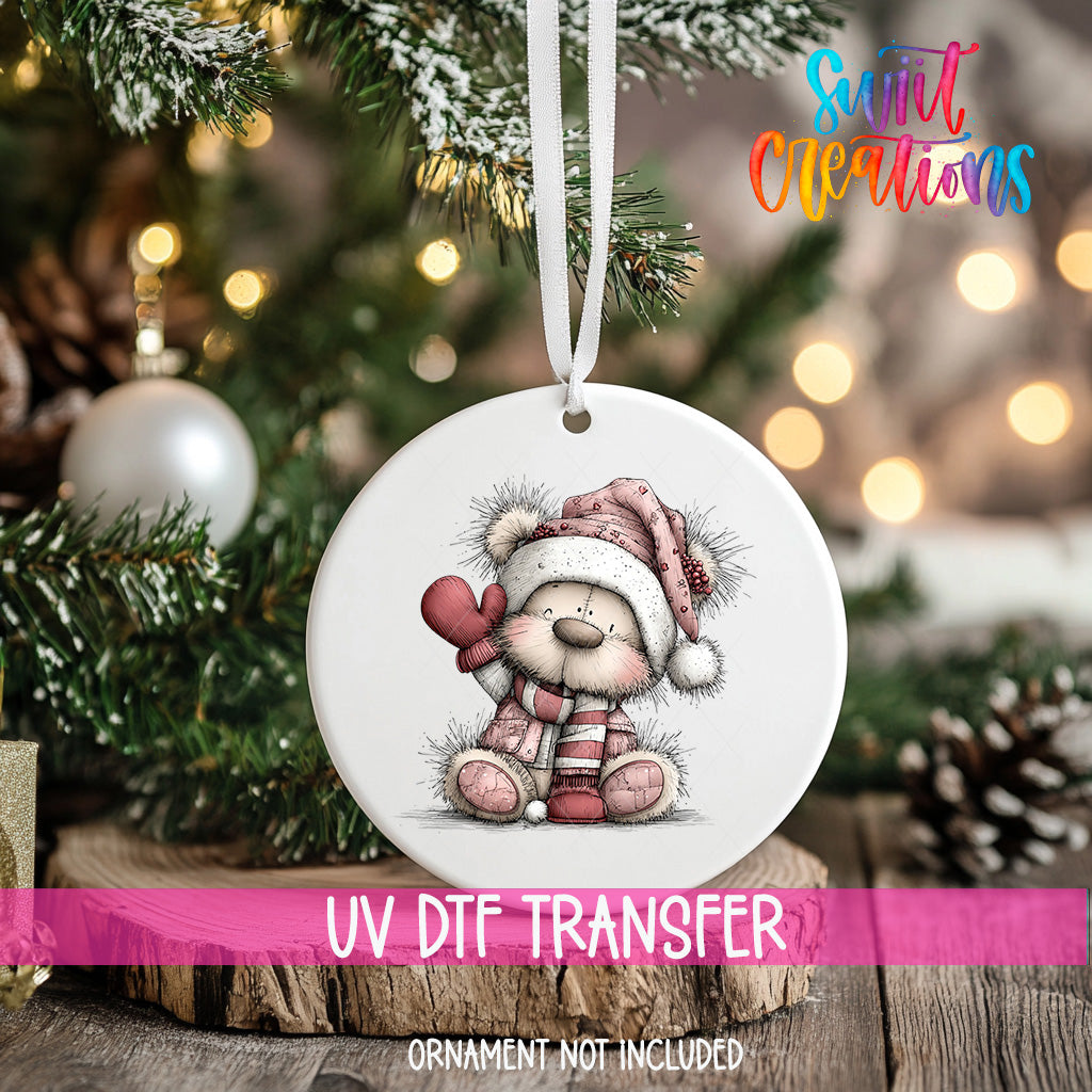 A white ceramic ornament with a teddy bear wearing a red hat and scarf, sitting on a wooden surface.