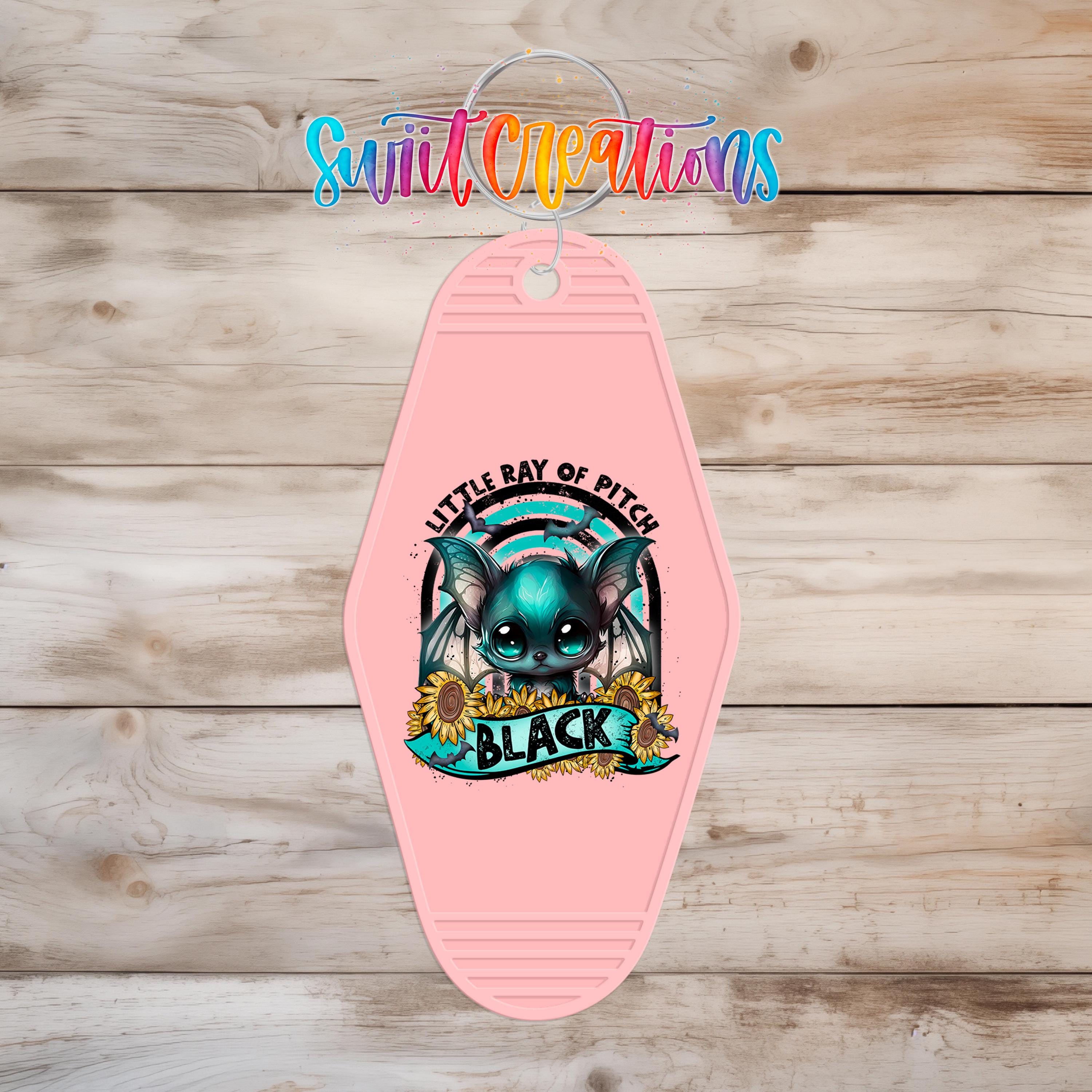 A pink keychain with a cartoon bat and the text "Little Ray of Pitch" printed on it.