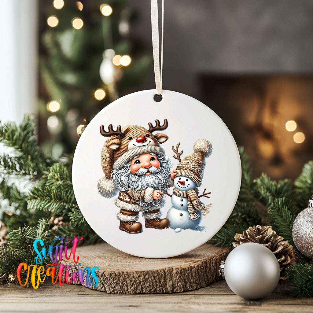 A white ceramic ornament featuring Santa Claus and a snowman, surrounded by Christmas decorations and greenery.