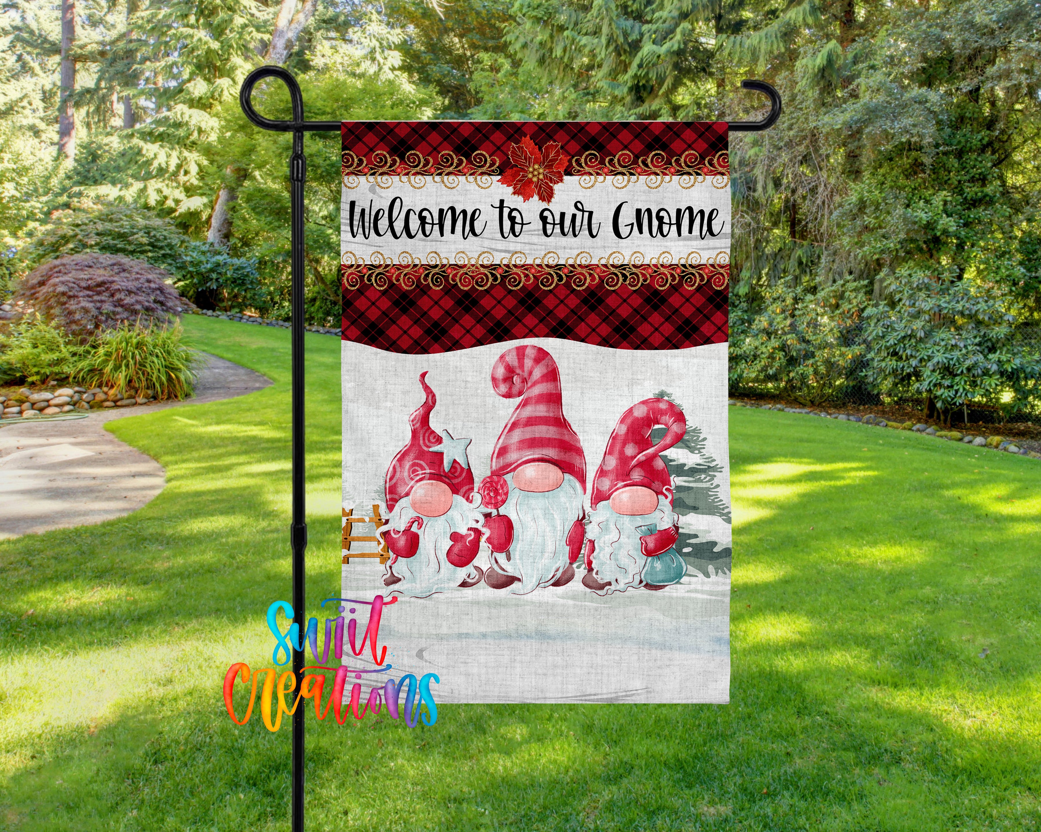 A garden flag featuring three red and white gnomes, with a snowy background and a "Welcome to our gnome" message.
