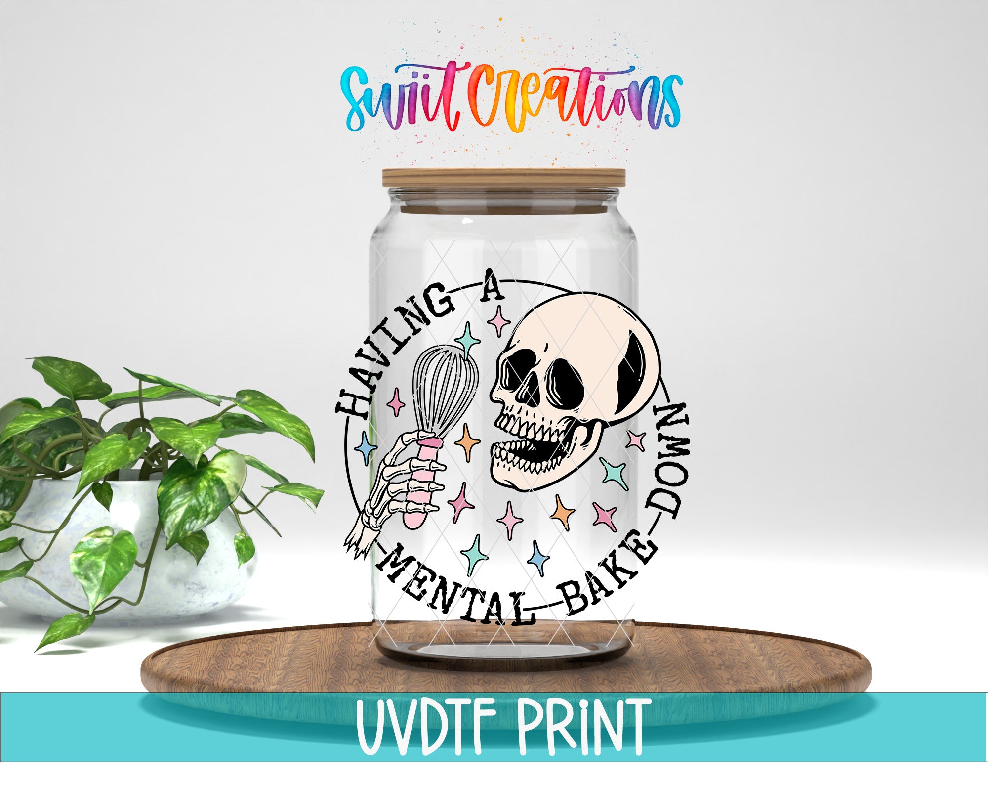 a glass jar with a skeleton and a whisk, surrounded by a circular design with the text "Having a MENTAL BAKED DOWN" and colorful stars. The jar is placed on a wooden surface, and there is a potted plant in the background.