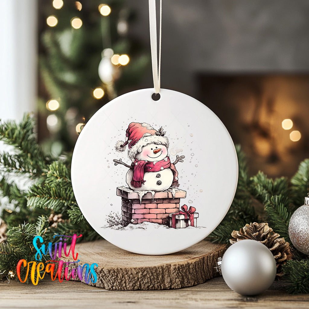 A white ceramic ornament featuring a snowman sitting on a brick chimney, surrounded by Christmas decorations and greenery.