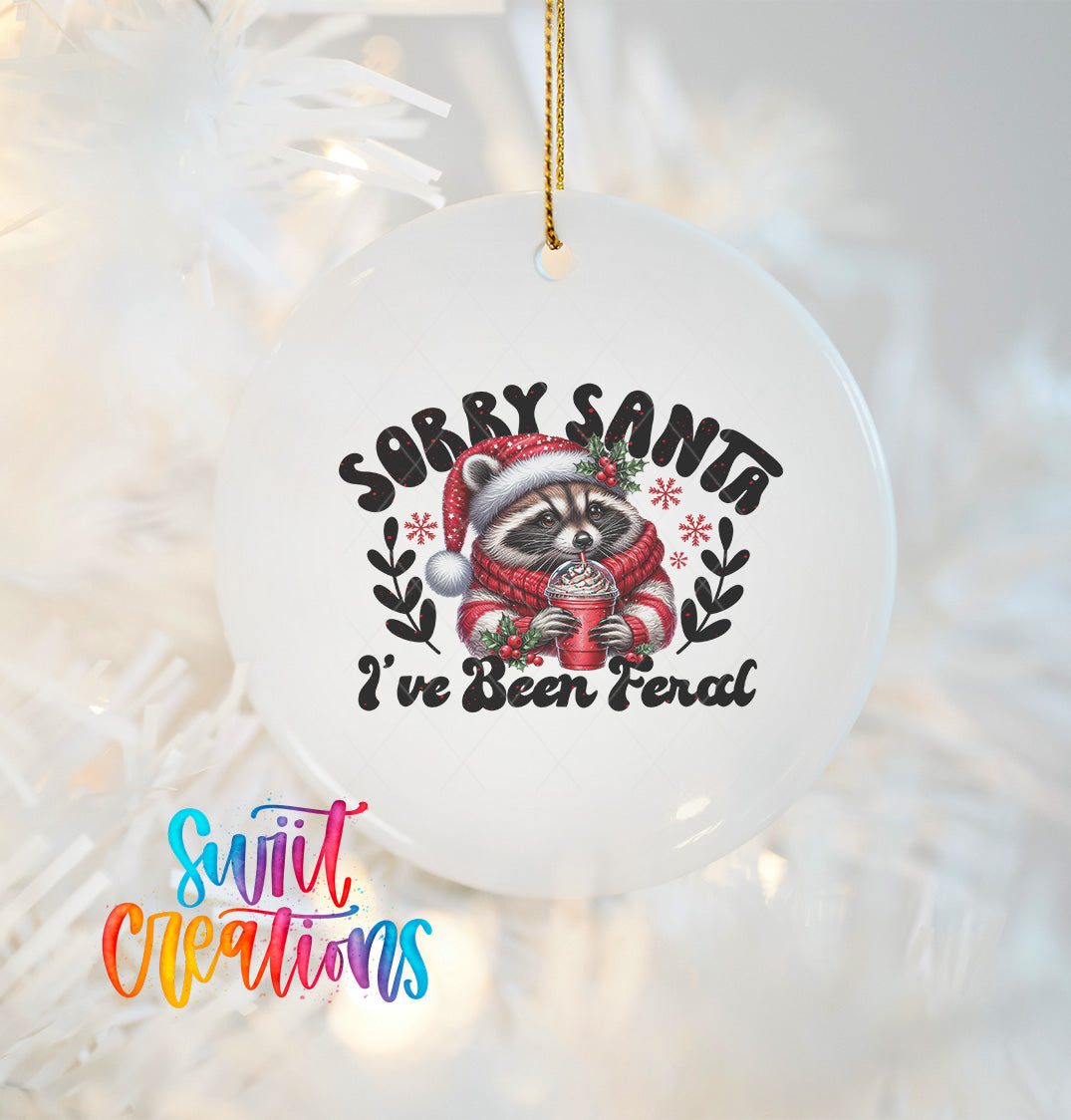A white ornament with a raccoon wearing a Santa hat and scarf, holding a cup of hot chocolate, and the text "Sorry Santa, I've been Felal" printed on it.