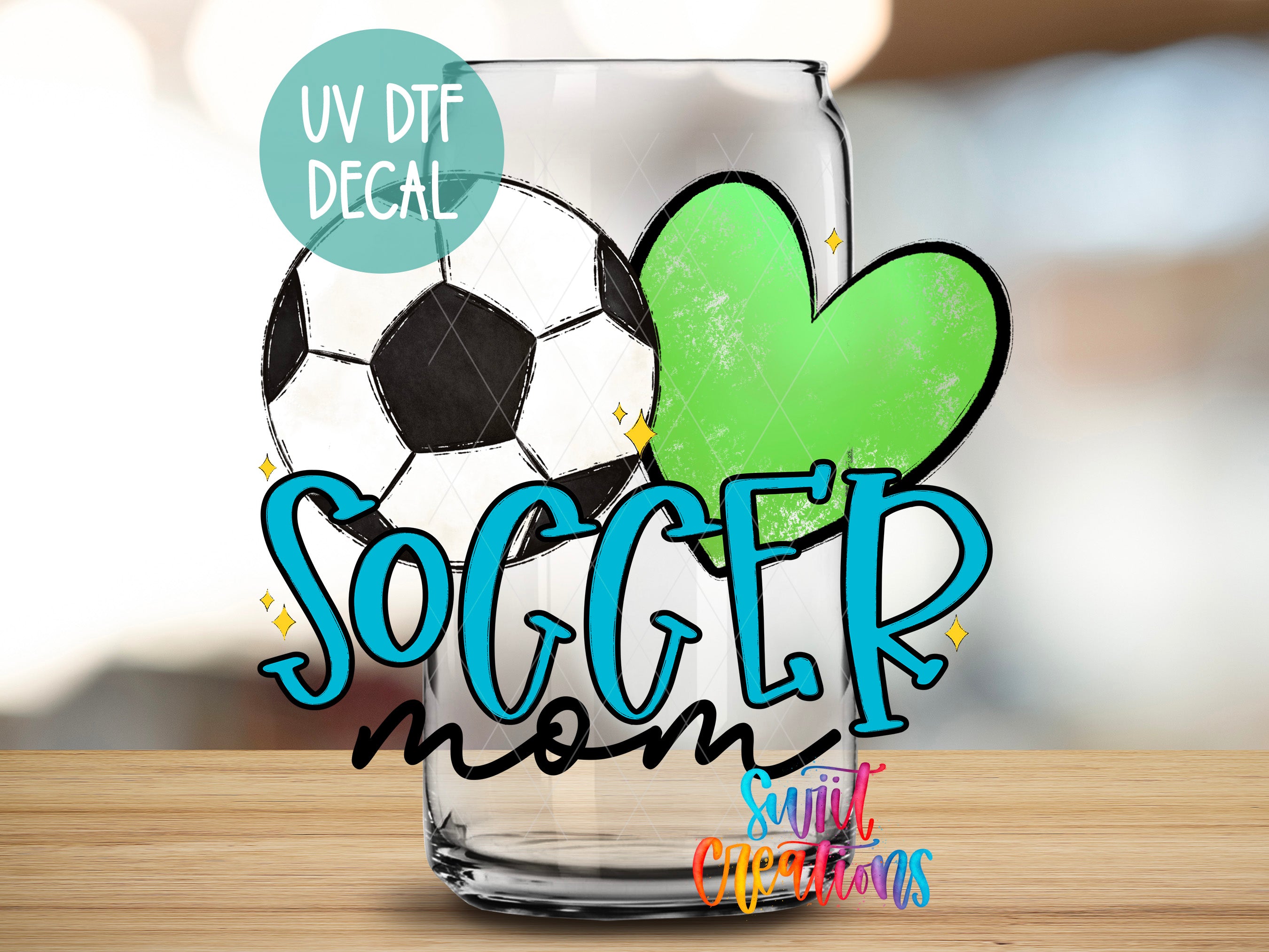 A glass with a soccer ball and a green heart, along with the text "SOCGER mom" and "SUNIT CREATIONS" written on it.