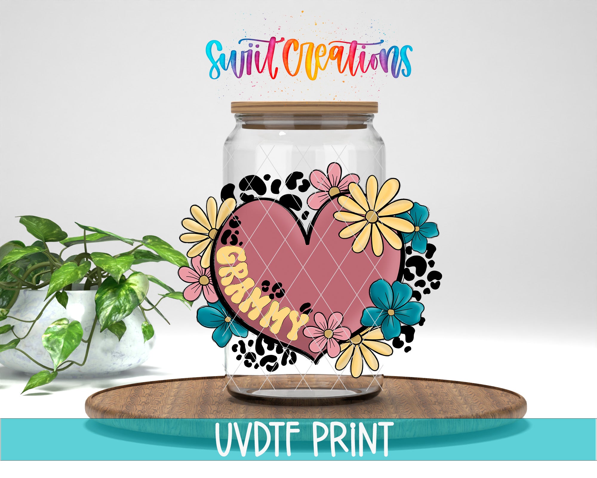 A glass jar with a heart-shaped design and colorful flowers, placed on a wooden surface. The jar has a label that says "GRAMMY". The background is white, and there is a plant in the background.