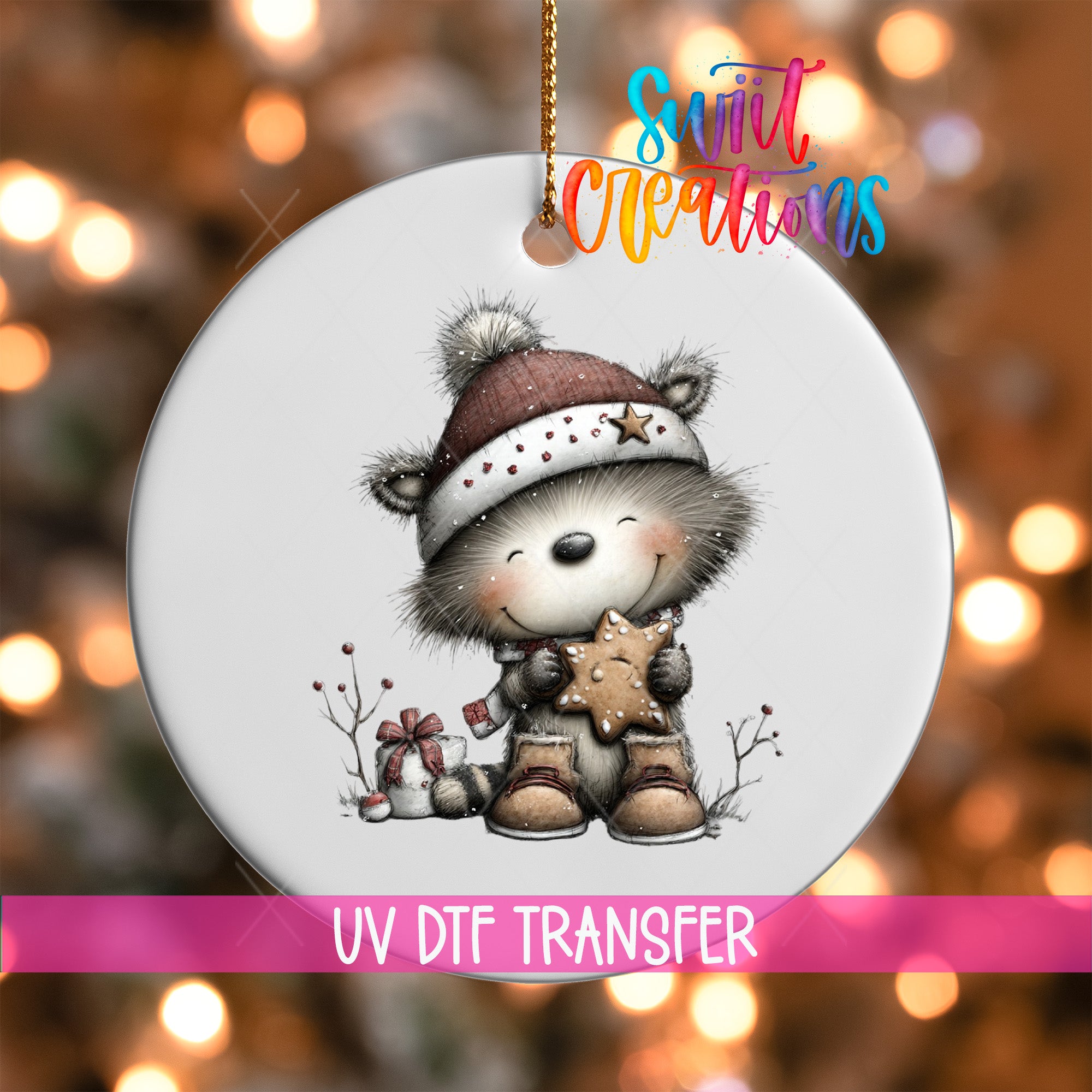 A white ornament featuring a cute raccoon wearing a hat and holding a star-shaped cookie, with a colorful background and text indicating it is a UV DFT transfer.