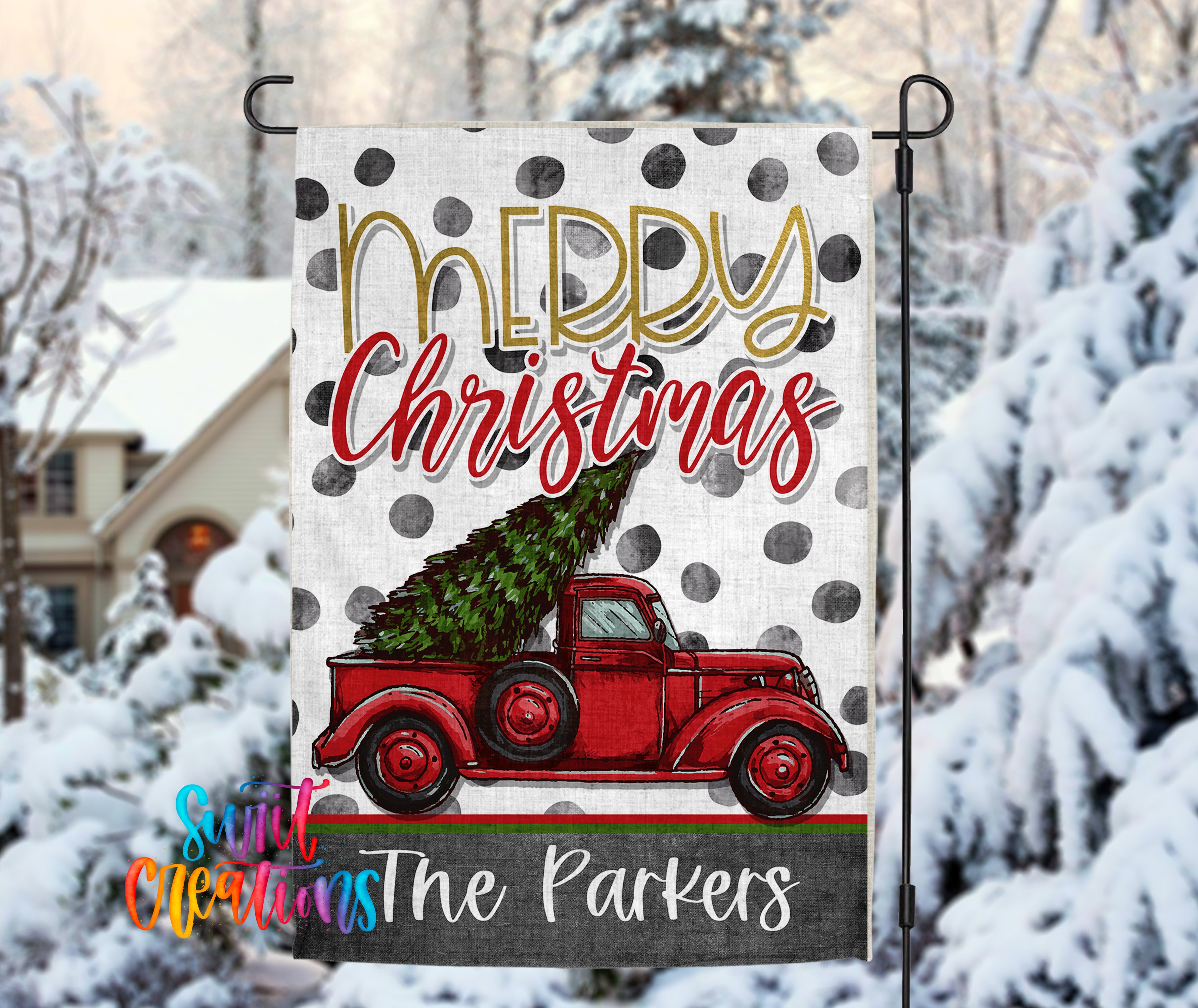 A festive Christmas-themed flag with a red truck carrying a decorated Christmas tree, set against a snowy background with trees and a house.