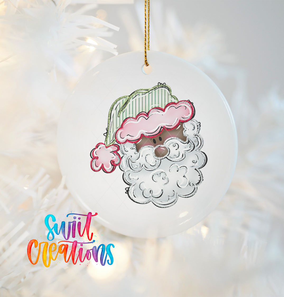 A white ornament with a colorful illustration of a smiling face, resembling a Santa Claus or a similar character, hanging on a string.