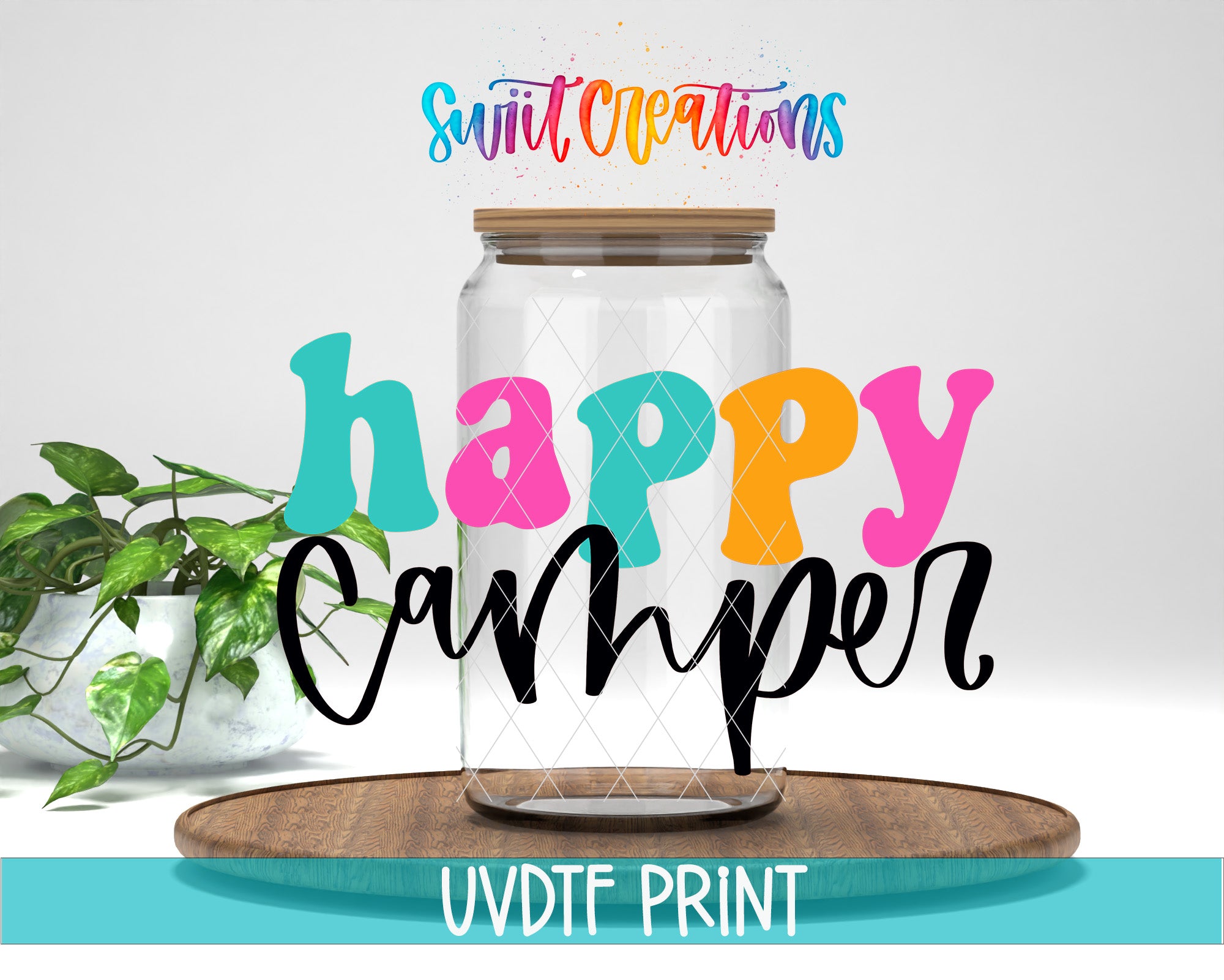 a glass jar with a lid, surrounded by colorful text that reads "Happy Camper" and "Swift Creations". The jar is placed on a wooden surface, and there is a plant in the background.