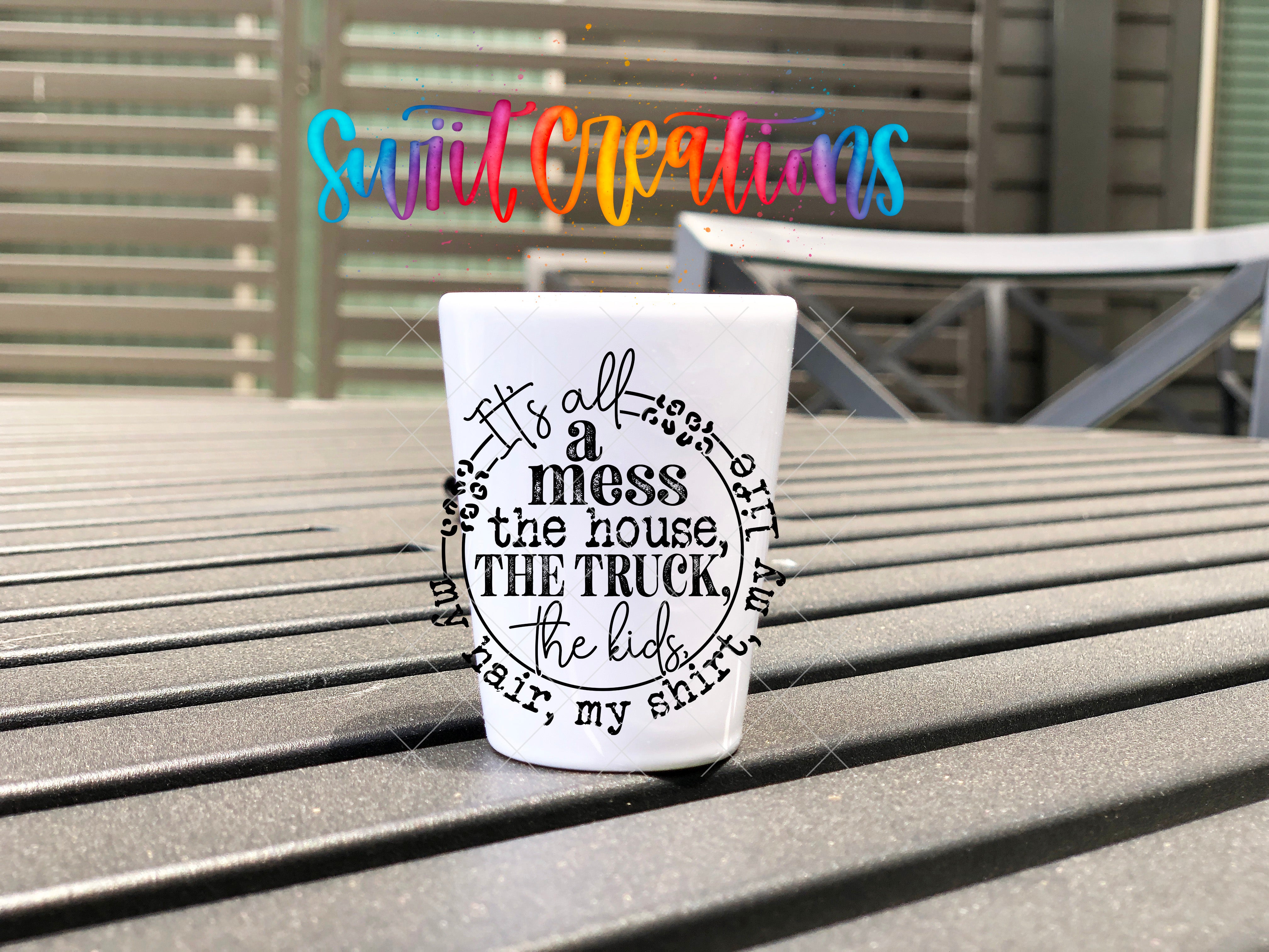 A white mug with a black text design on it, placed on a wooden surface.