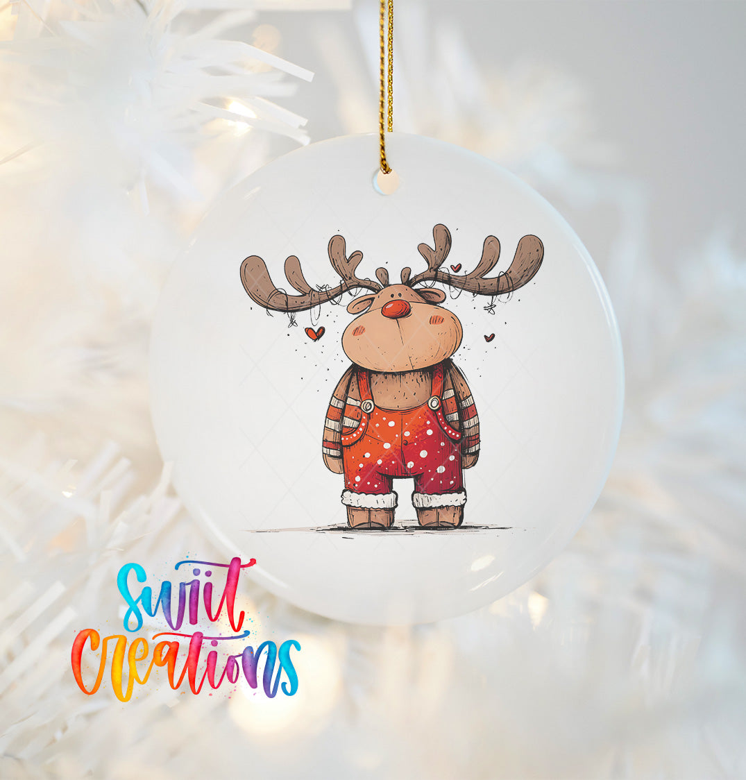 A white ornament featuring a cartoon reindeer with antlers and a red bow tie, hanging on a Christmas tree.