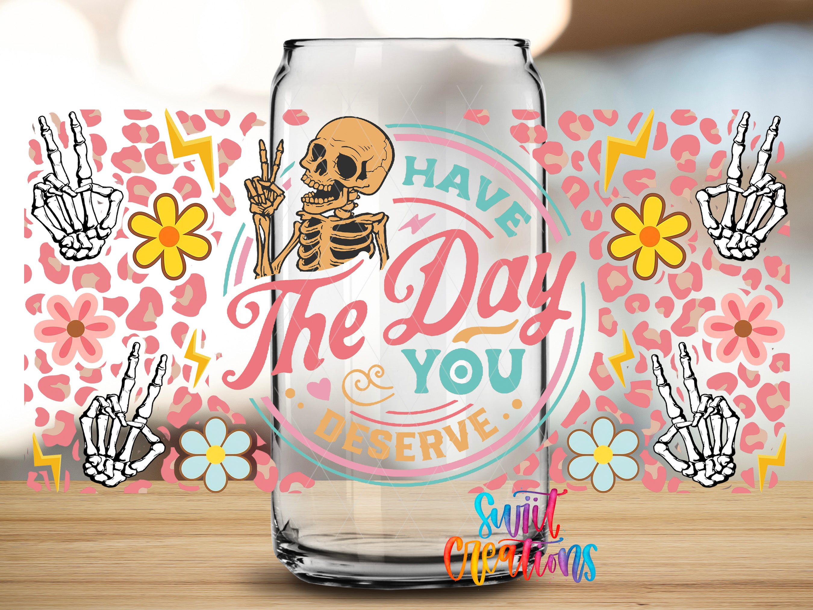 a glass can with a skeleton and floral design, along with the text "The Day You Deserve" and a peace sign.