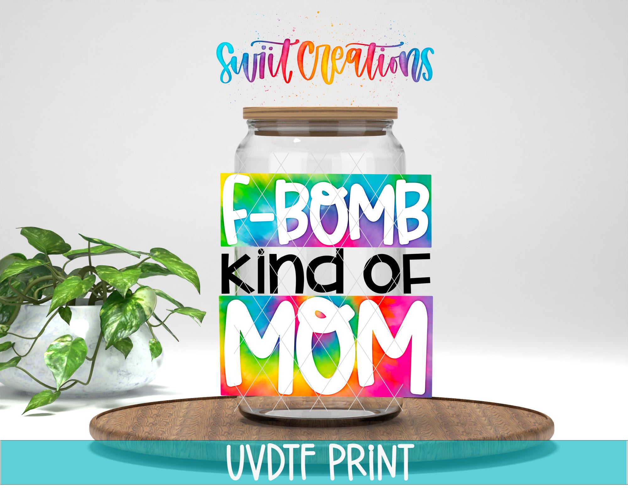 a glass jar with a colorful design, including the text "F-BOMB KIND OF MOM" and the logo "Swift Creations". The jar is placed on a wooden surface, and there is a potted plant in the background.