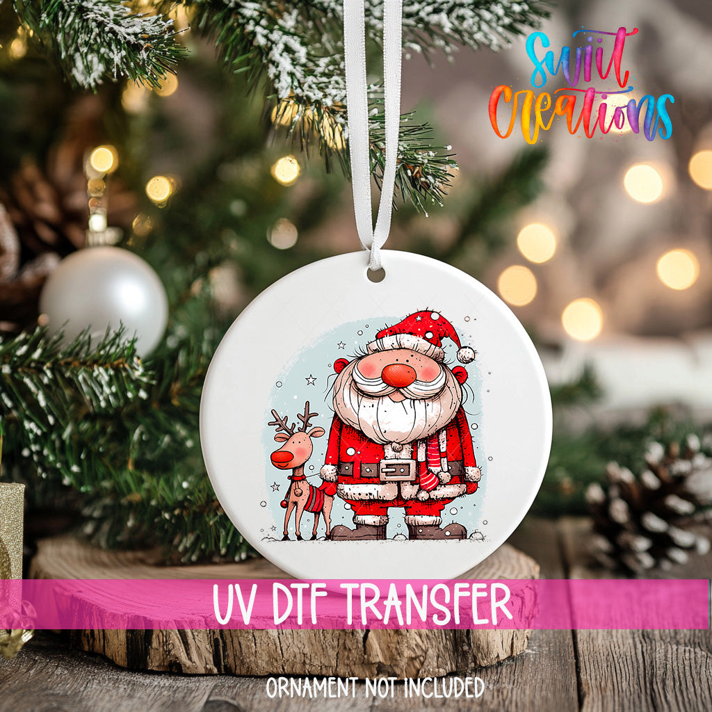 A white ornament featuring a Santa Claus and reindeer on a Christmas tree, with a pink ribbon around it.