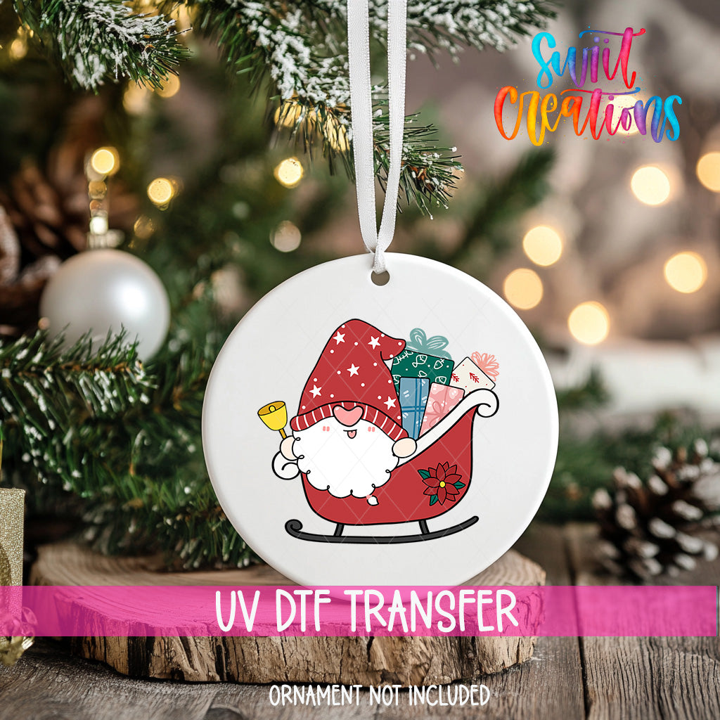 A white ornament with a red and white gnome on a sled, surrounded by Christmas decorations, including a Christmas tree and ornaments.