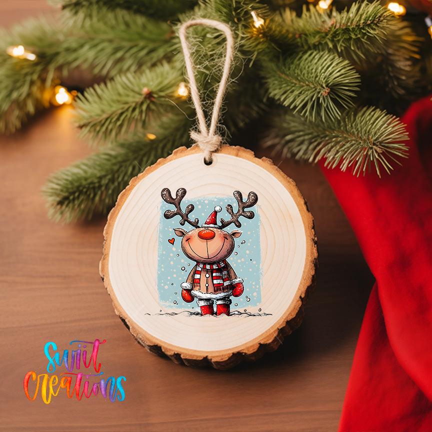 A wooden ornament featuring a cartoon reindeer is hanging on a Christmas tree, surrounded by pine branches and twinkling lights.