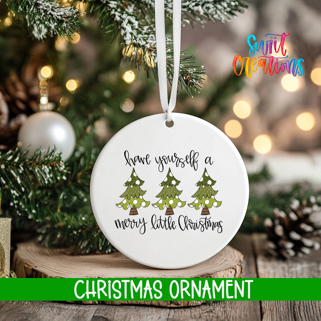 A white Christmas ornament with a message that says "Have yourself a merry little Christmas" is hanging on a tree.