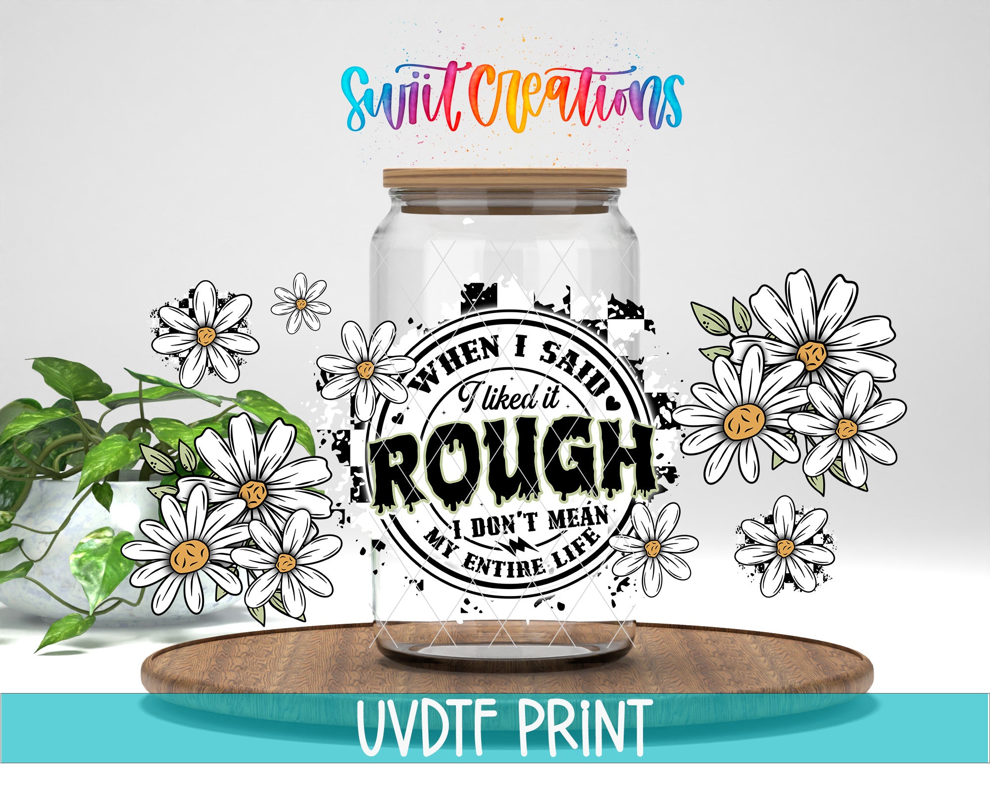 a clear glass jar with a printed design on it, surrounded by white flowers and a wooden tray. The text on the jar reads "When I said it's rough, I don't mean my entire life".