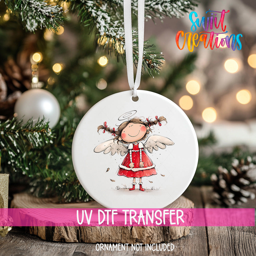 A white ceramic ornament with a smiling angel figure is hanging on a Christmas tree.