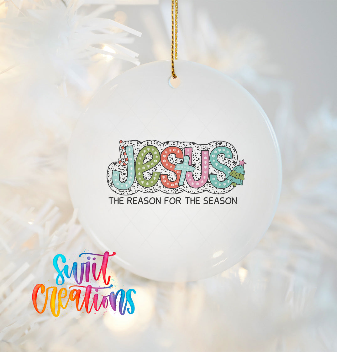 A white ornament with the word "JESUS" written in a colorful, hand-drawn style.