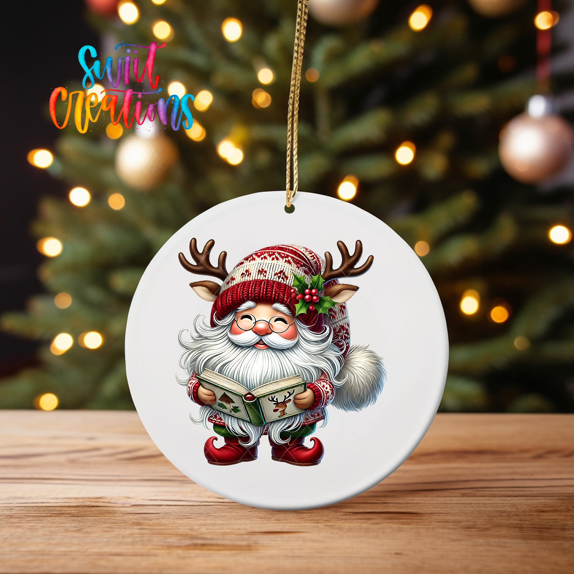 A white ornament featuring a cartoon Santa Claus holding a book and wearing a red and white hat with antlers, set against a blurred background of Christmas lights.