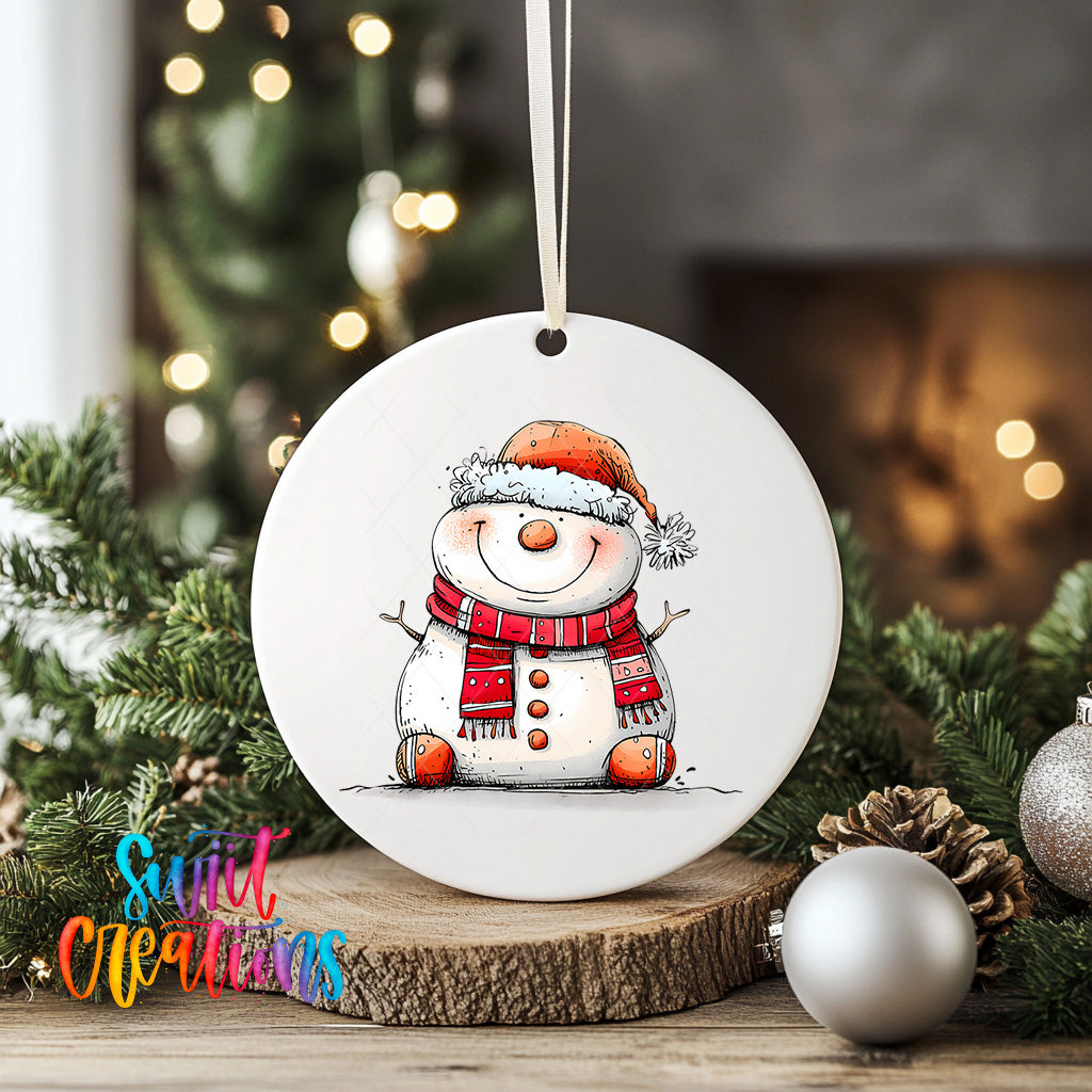 A white ceramic ornament featuring a smiling snowman wearing a red scarf and hat, surrounded by Christmas decorations and greenery.