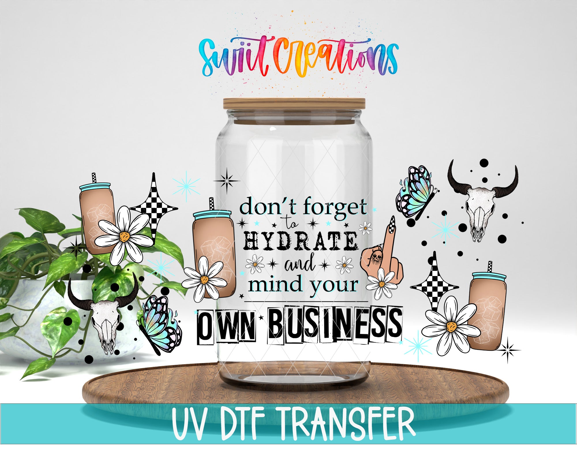 The image is a colorful and whimsical advertisement featuring a glass jar with a straw, surrounded by various decorative elements such as flowers, butterflies, and skulls. The text on the jar reads "don't forget to hydrate and mind your own business", and the background includes a plant and a wooden tray. The image also includes the text "UV DFT TRANSFER" at the bottom.