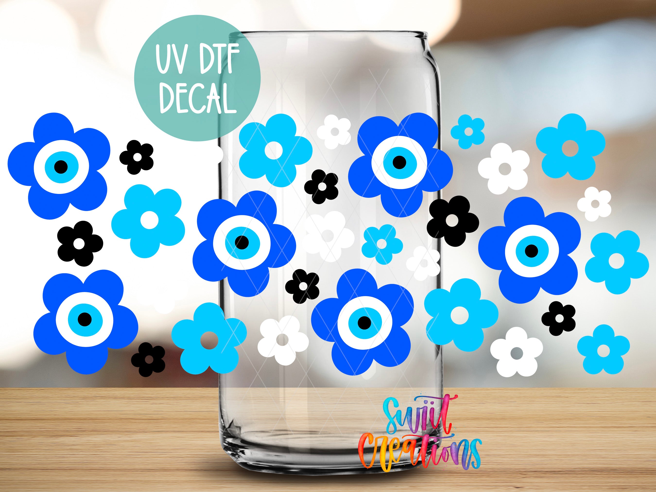 a clear glass jar with various blue and white flower decals on it, placed on a wooden surface.
