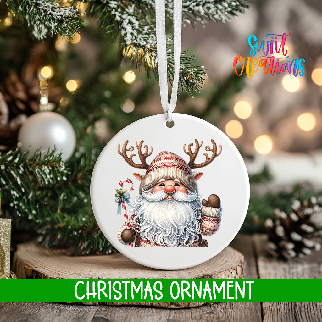 A white Christmas ornament featuring a smiling Santa Claus with antlers, surrounded by pine branches and twinkling lights.