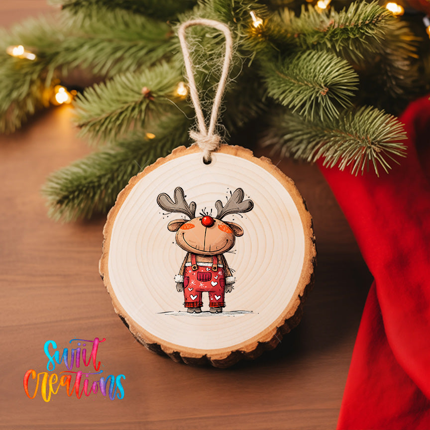 A wooden ornament featuring a cartoon reindeer is hanging on a Christmas tree, surrounded by pine branches and twinkling lights.