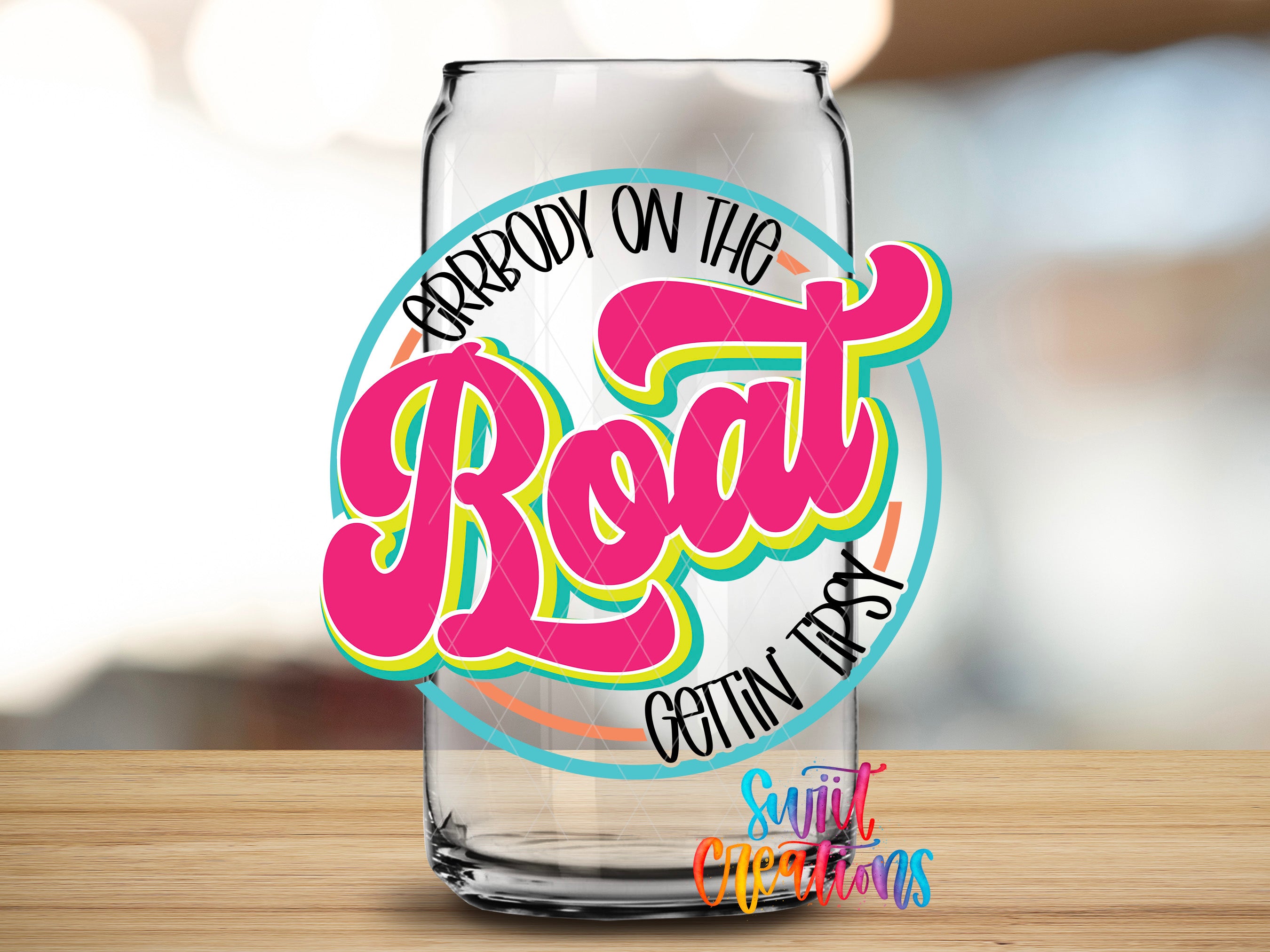 A glass can with a colorful, stylized text design on it, placed on a wooden surface.