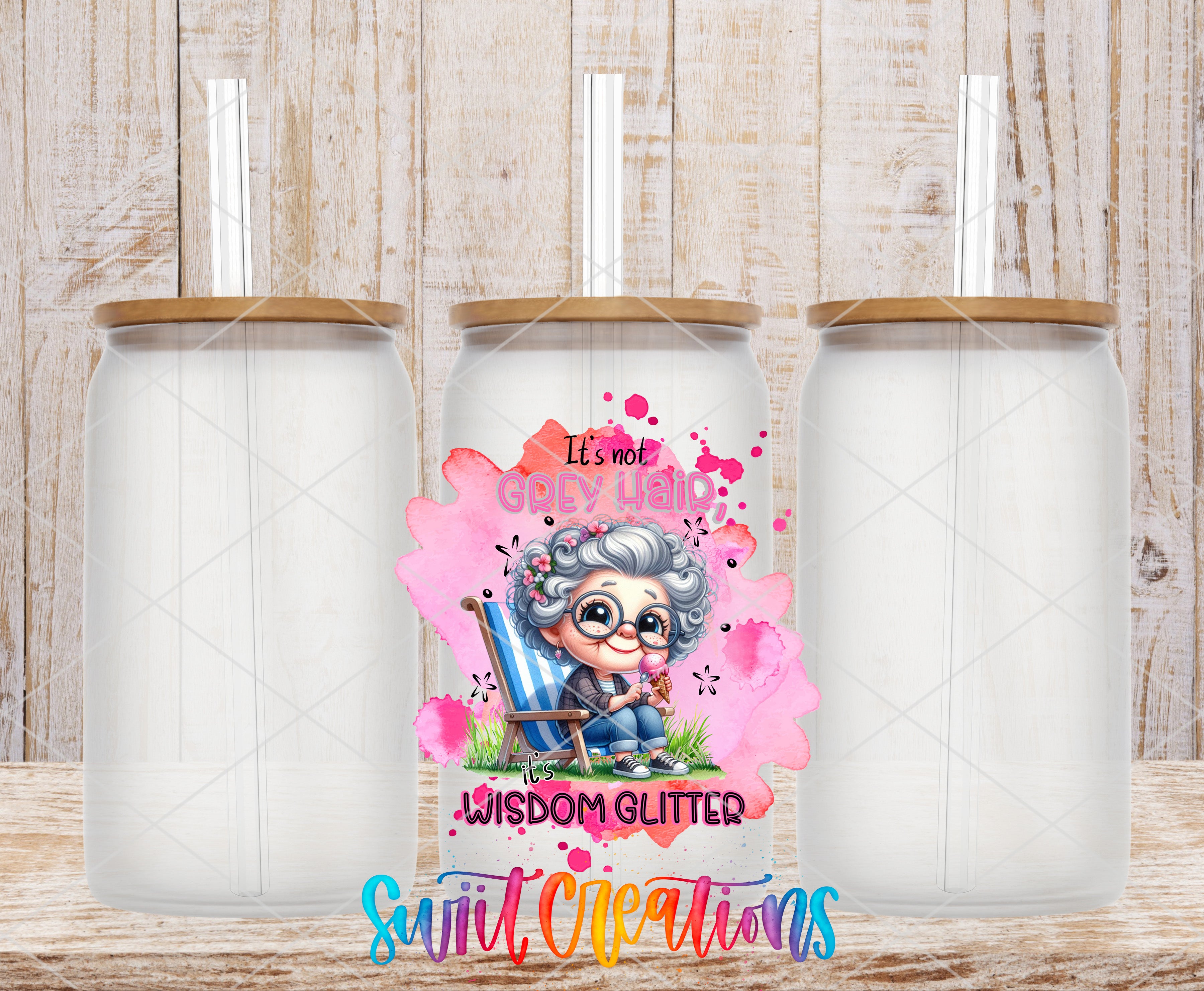 three empty glass jars with straws, each with a unique design and color. The central jar has a colorful illustration of an elderly woman with a pink background and the text "It's not GODY GLITTER Wisdom Glitter" written below the illustration.