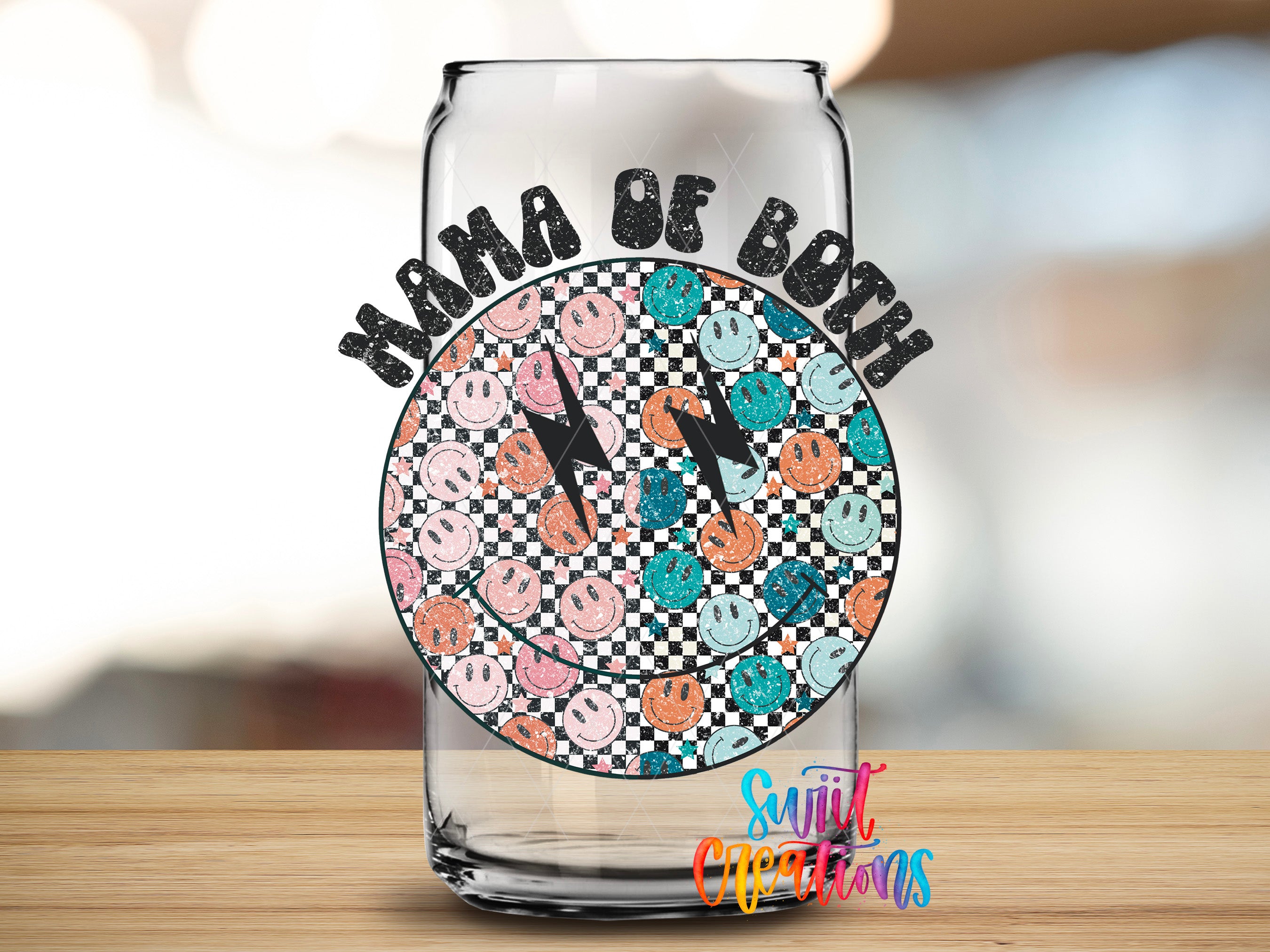 A glass can with a design featuring a smiley face pattern and the text "Mama of both" written above it.