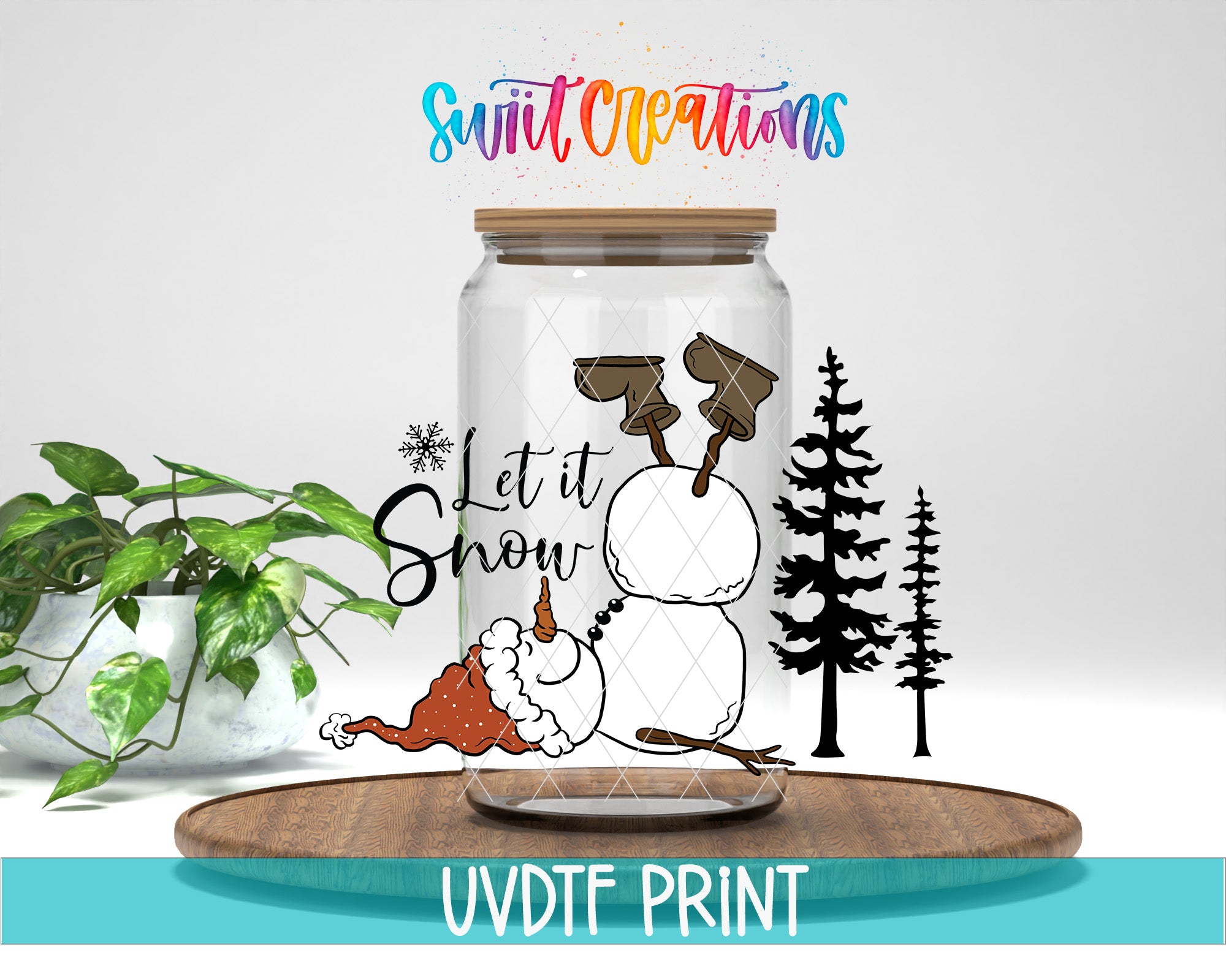 A glass jar with a snowman and pine trees on it, along with the text "Let it Snow" and a snowflake graphic. The jar is placed on a wooden surface, and there is a plant in the background.