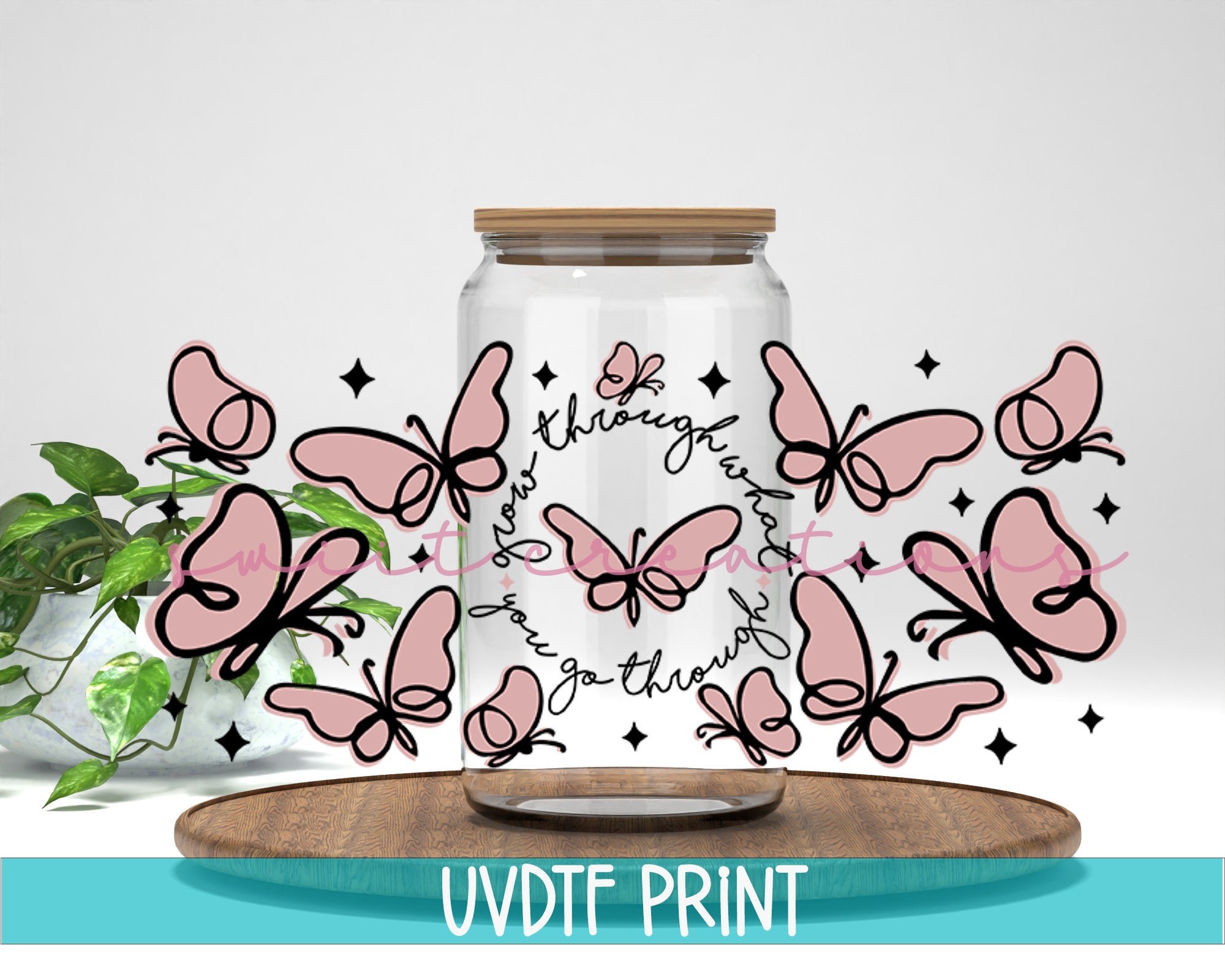a jar filled with pink butterflies sitting on top of a wooden table