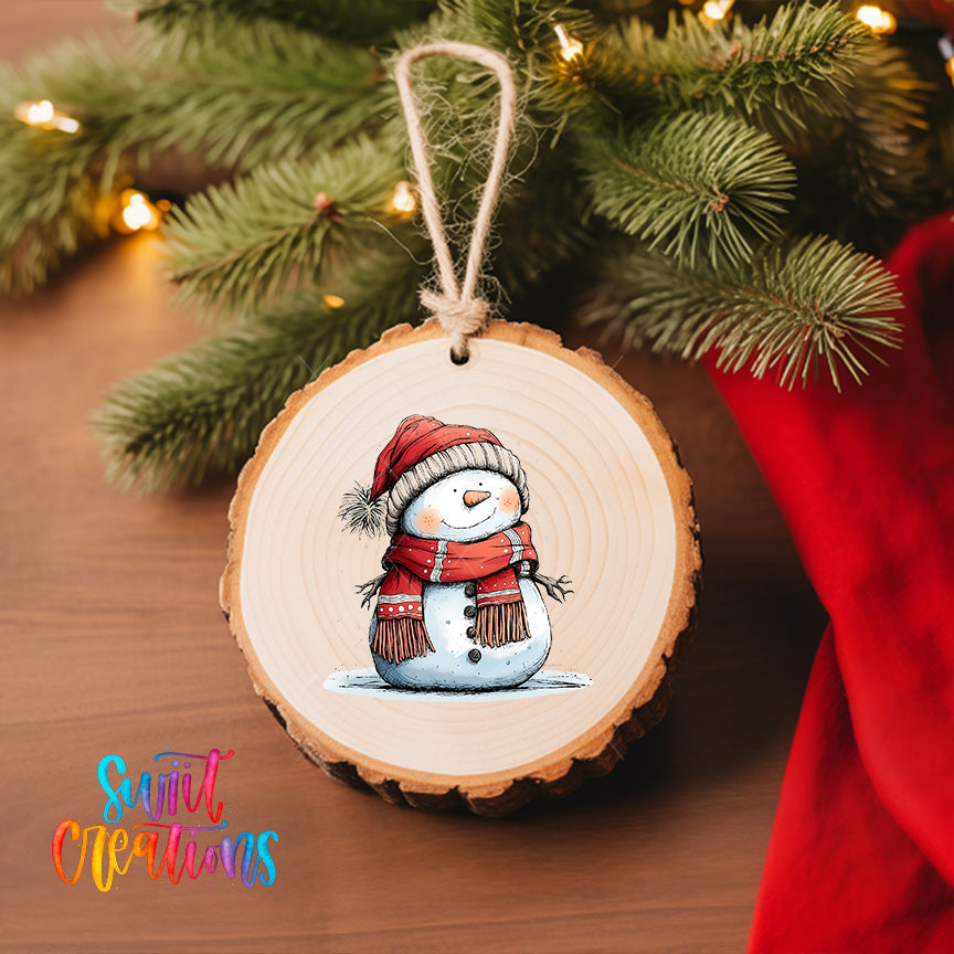 A wooden ornament featuring a snowman is hanging on a Christmas tree, with a red cloth visible in the background.