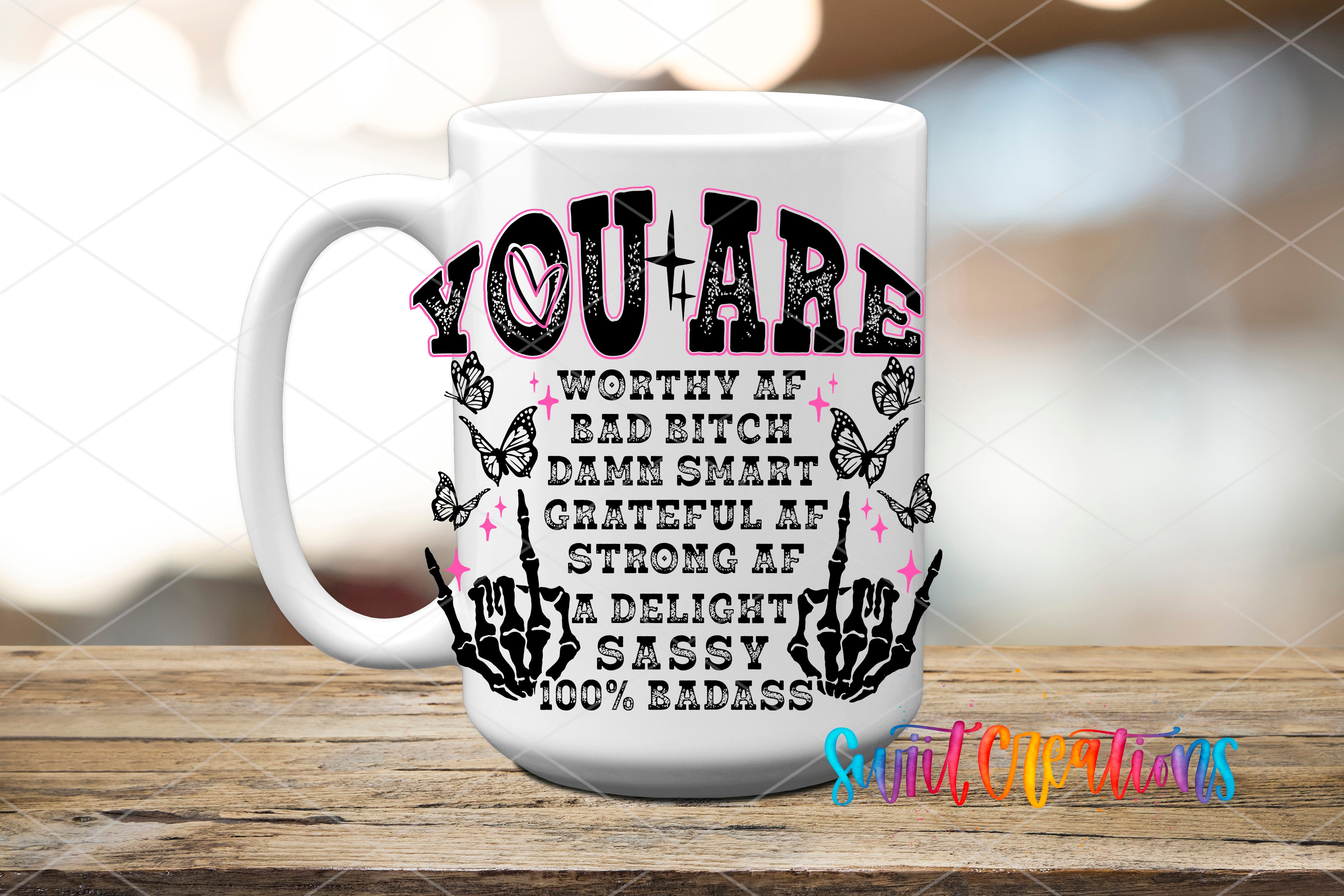 A white mug with a black and pink design featuring text and graphics.