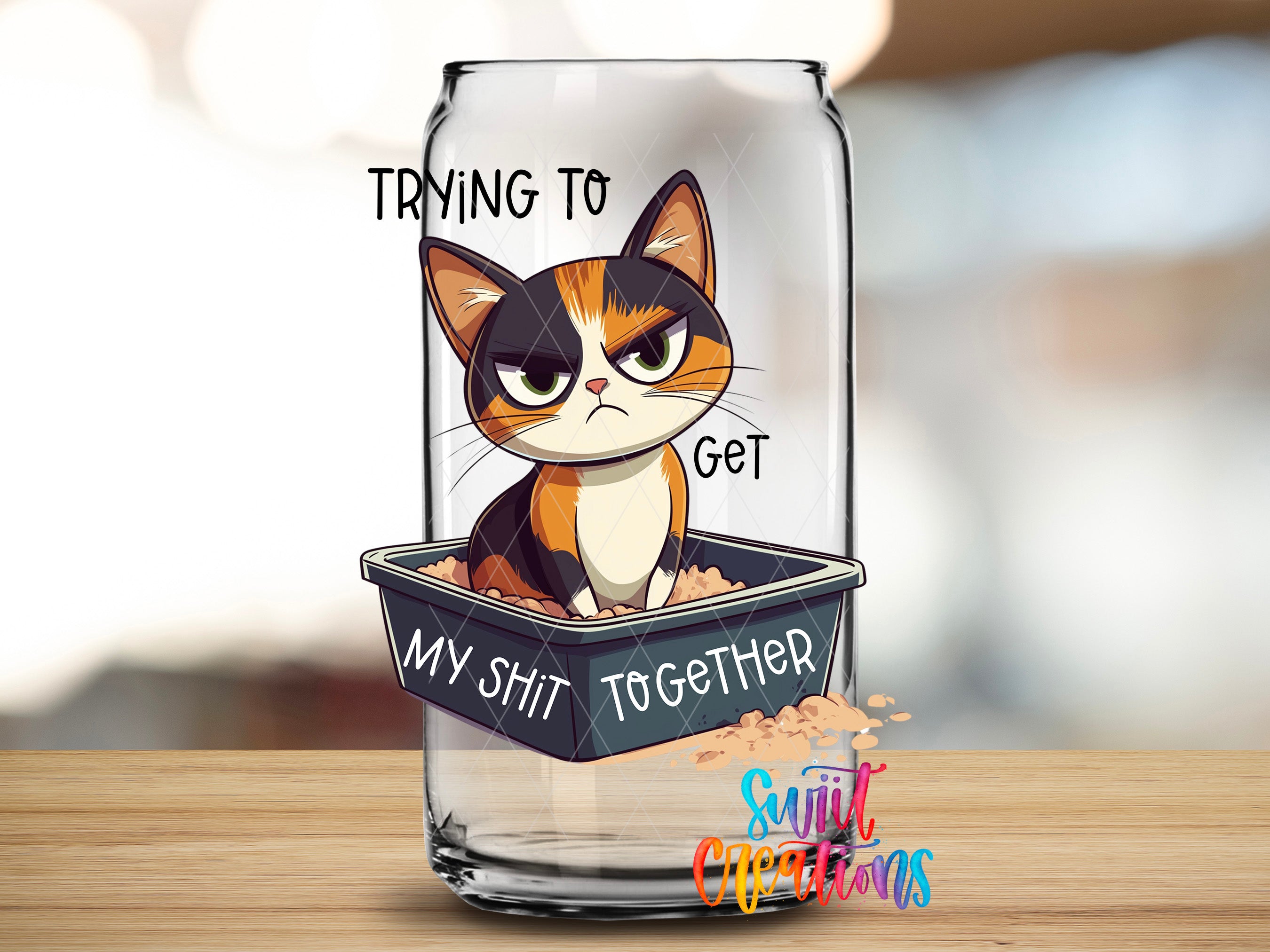 A glass can with a cartoon cat sitting inside it, and the cat appears to be making a mean face. The text on the can reads "Trying to get my shit together" and "My shit together".