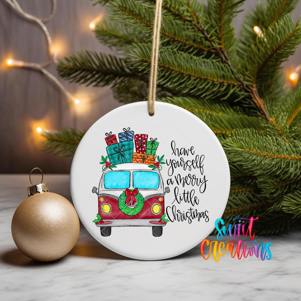 A white ceramic ornament with a red and white van illustration, surrounded by Christmas decorations and a Christmas tree.