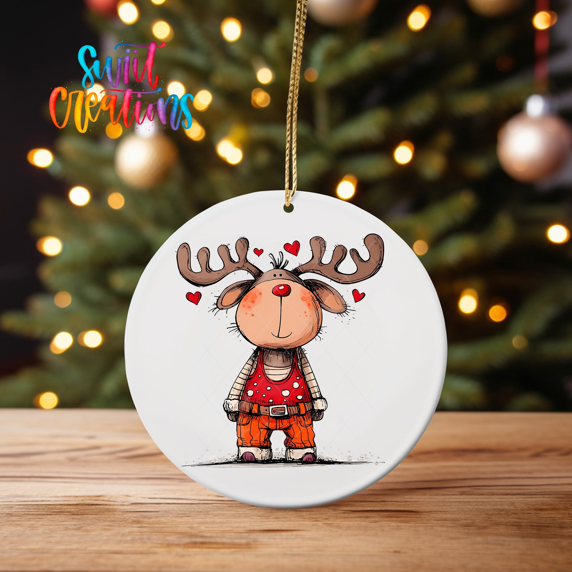 A white oval ornament featuring a cartoon reindeer with antlers and a red nose, surrounded by hearts, is hanging from a string.