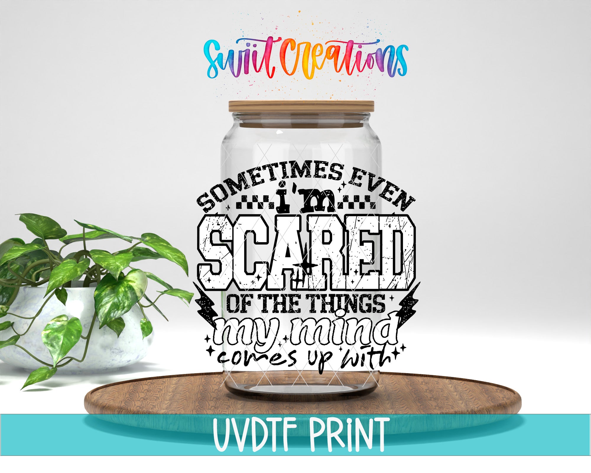 a large glass jar with a wooden lid, placed on a wooden surface. The jar has a printed text on it that reads "Sometimes even scared of the things my mind comes up with". The background of the image is white, and there is a plant visible in the background.