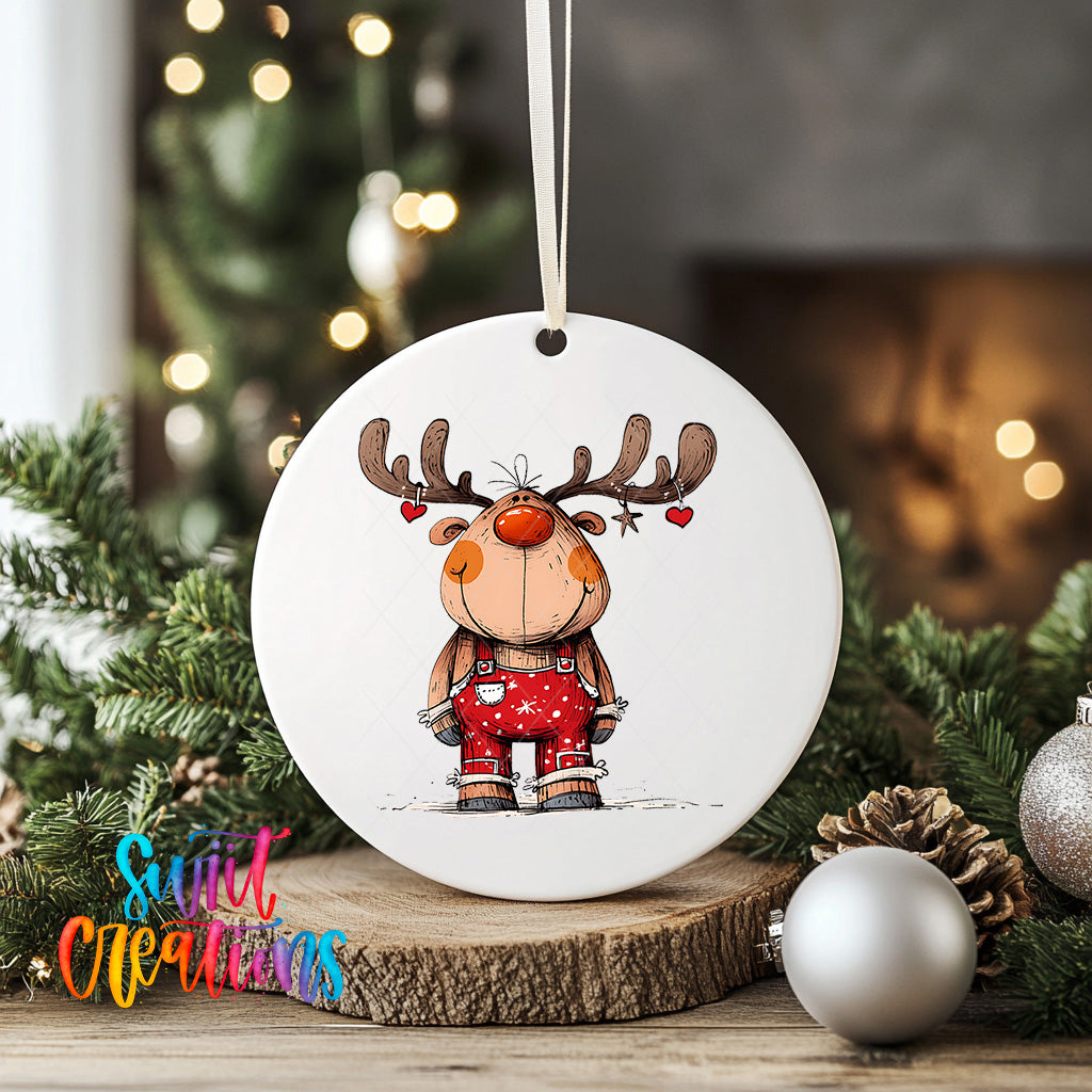 A white ornament featuring a cartoon reindeer with antlers and a red bow tie, surrounded by Christmas decorations and greenery.