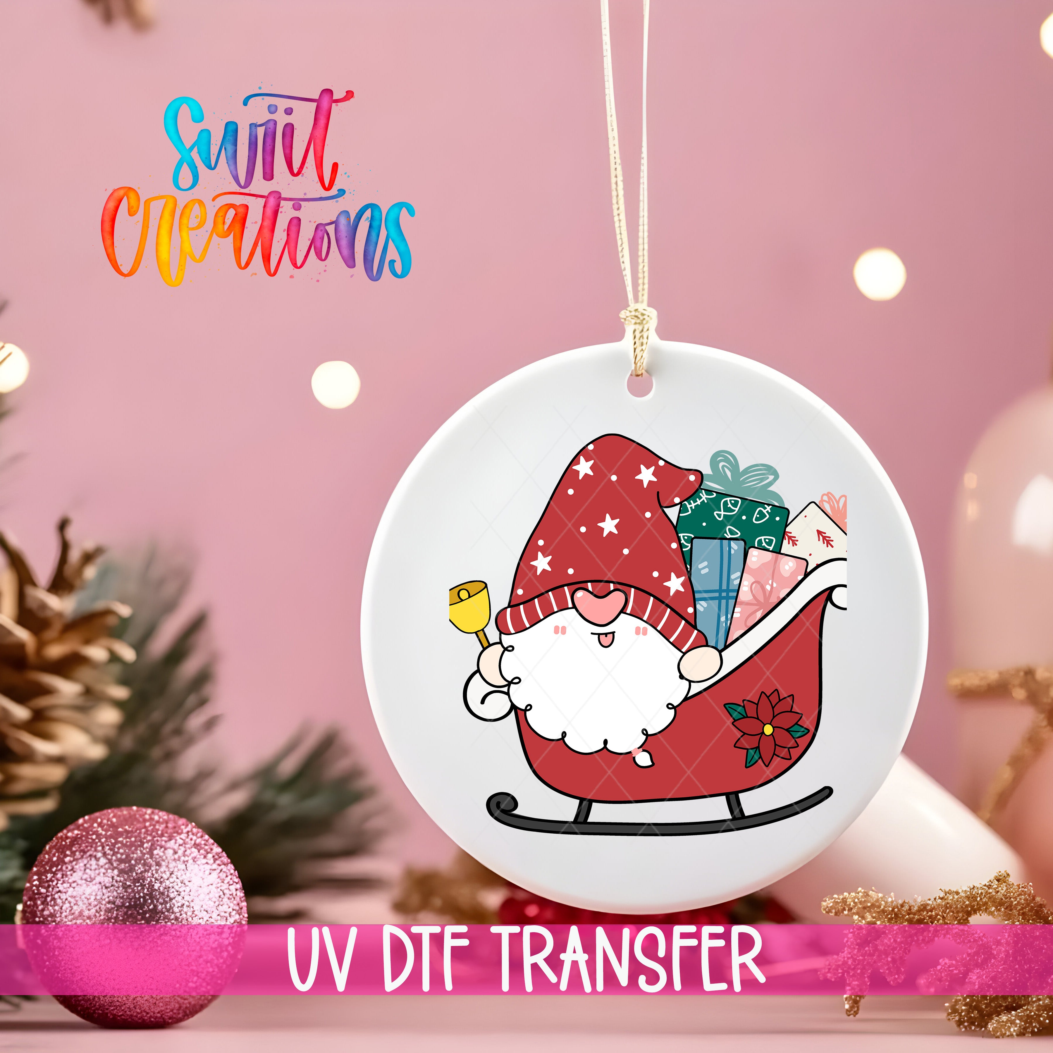 A white ornament with a gnome riding a sled, holding presents, is hanging on a string against a pink background with Christmas decorations.