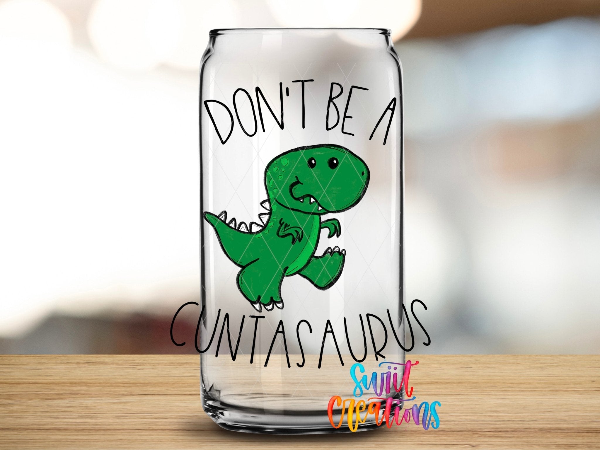 Glass can displaying the Swiit Creations Don’t Be a Cuntasaurus UV DTF transfer with a green cartoon dinosaur.