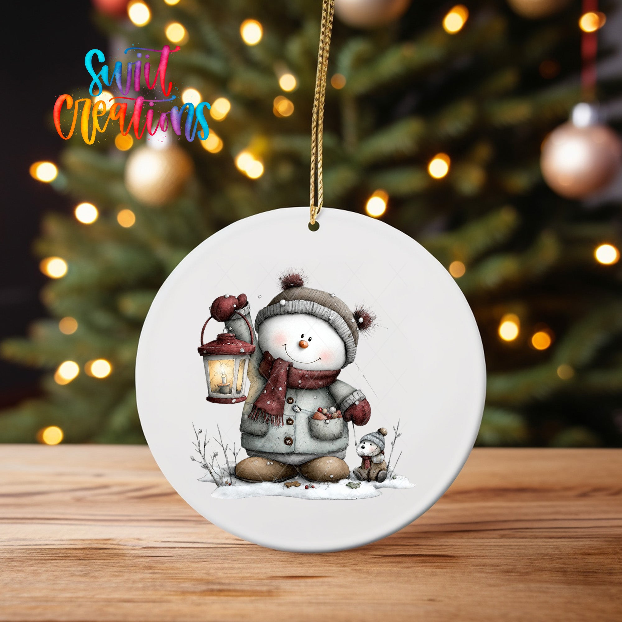 A white ceramic ornament featuring a snowman holding a lantern, with a cat nearby, against a blurred background of Christmas lights.